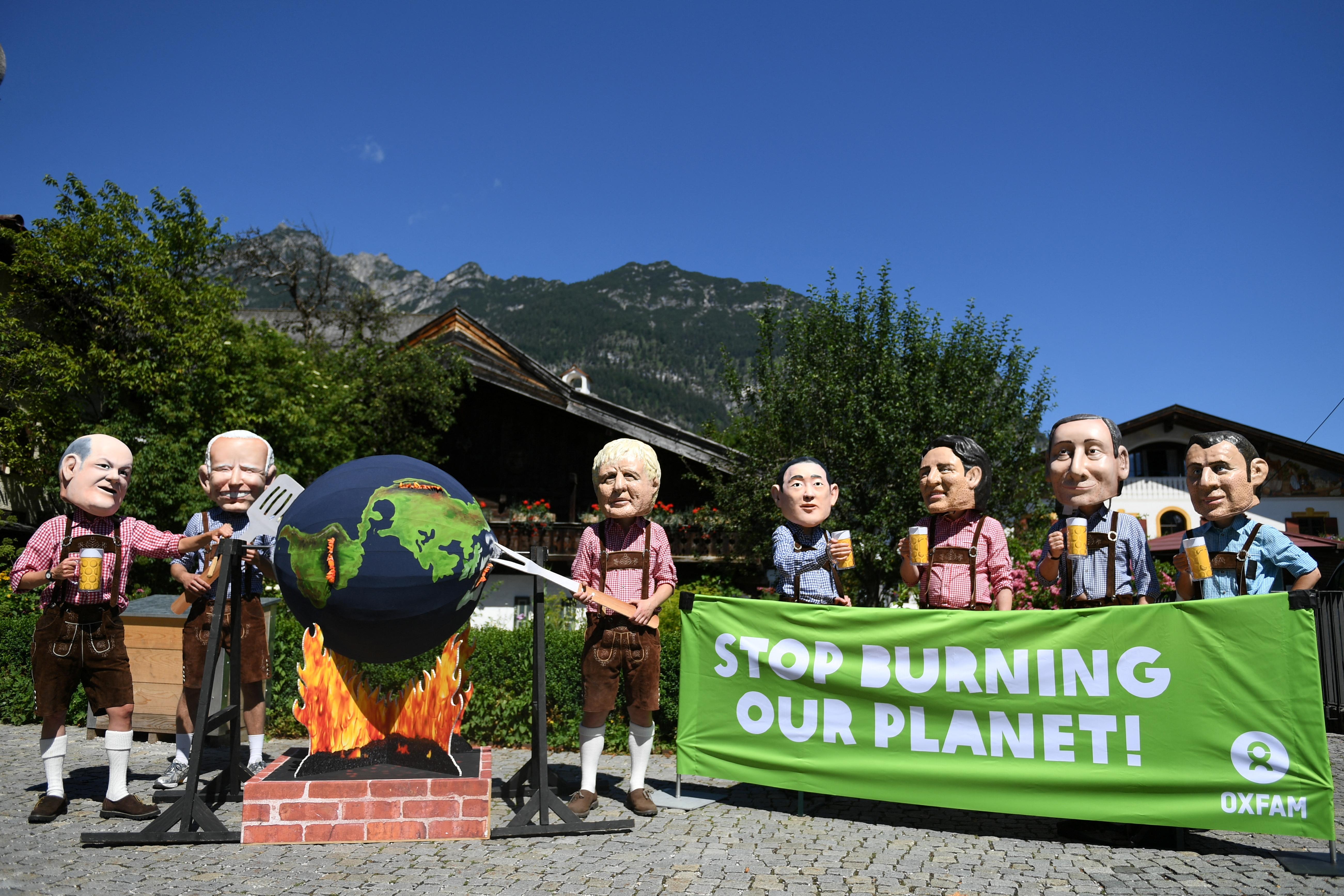 Los activistas de Oxfam usan cabezas que representan a los líderes del G7 en el castillo de Schloss Elmau, mientras actúan durante una protesta en Garmisch-Partenkirchen, Alemania, el 26 de junio de 2022. REUTERS/Andreas Gebert
