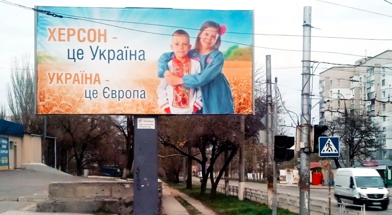 Una valla publicitaria que aún no fue derribada por las fuerzas ocupantes en una calle semidesierta de Kherson. Dice: "Kherson es Ucrania. Ucrania es Europa".