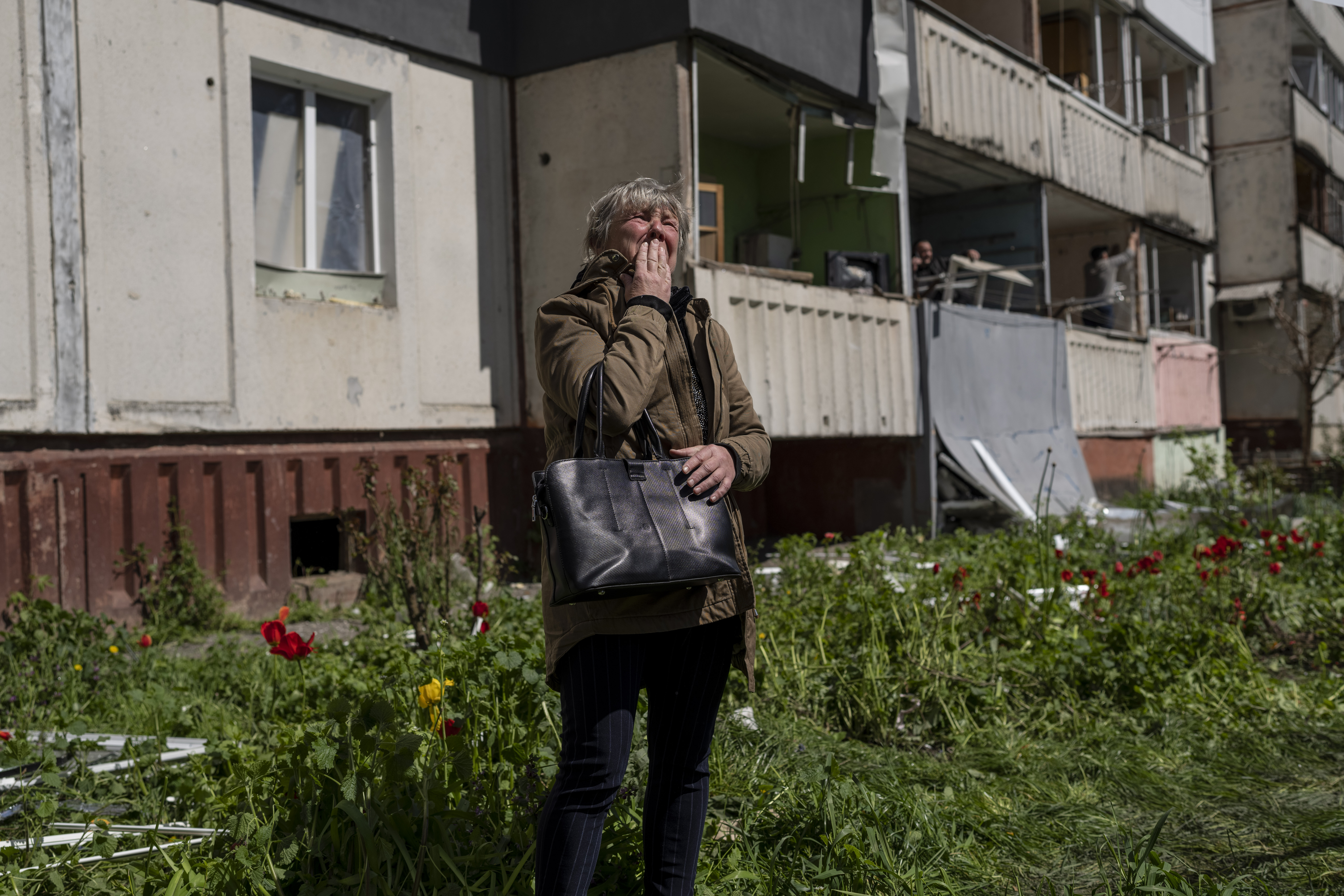 Una mujer llora mientras observa la destrucción de un edificio residencial que fue alcanzado durante un ataque ruso en Uman, Ucrania central, el viernes 28 de abril de 2023. (AP/Bernat Armangue)