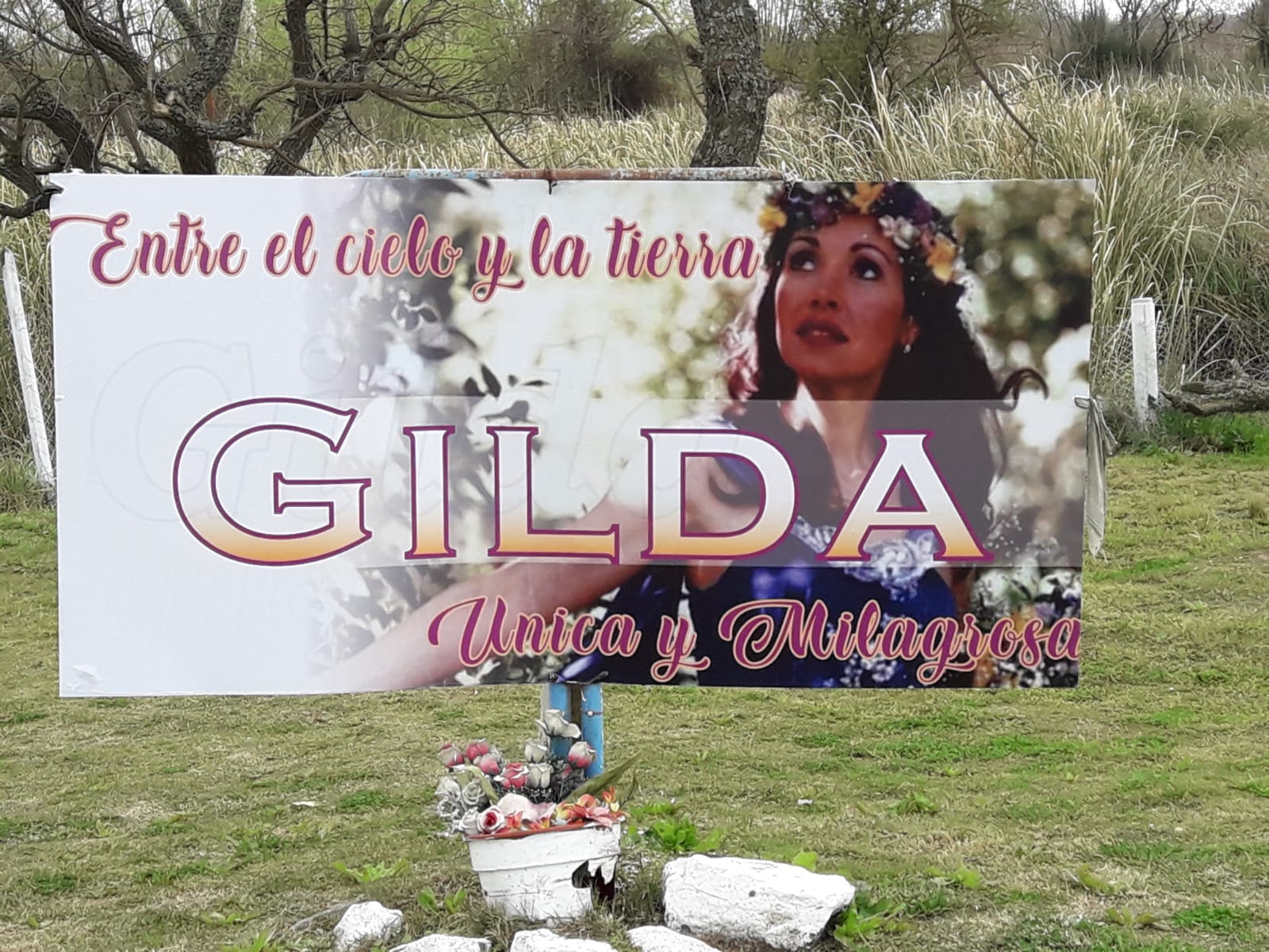 Uno de los cientos de carteles y banderas que en el santuario hablan de los milagros de "Santa Gilda"