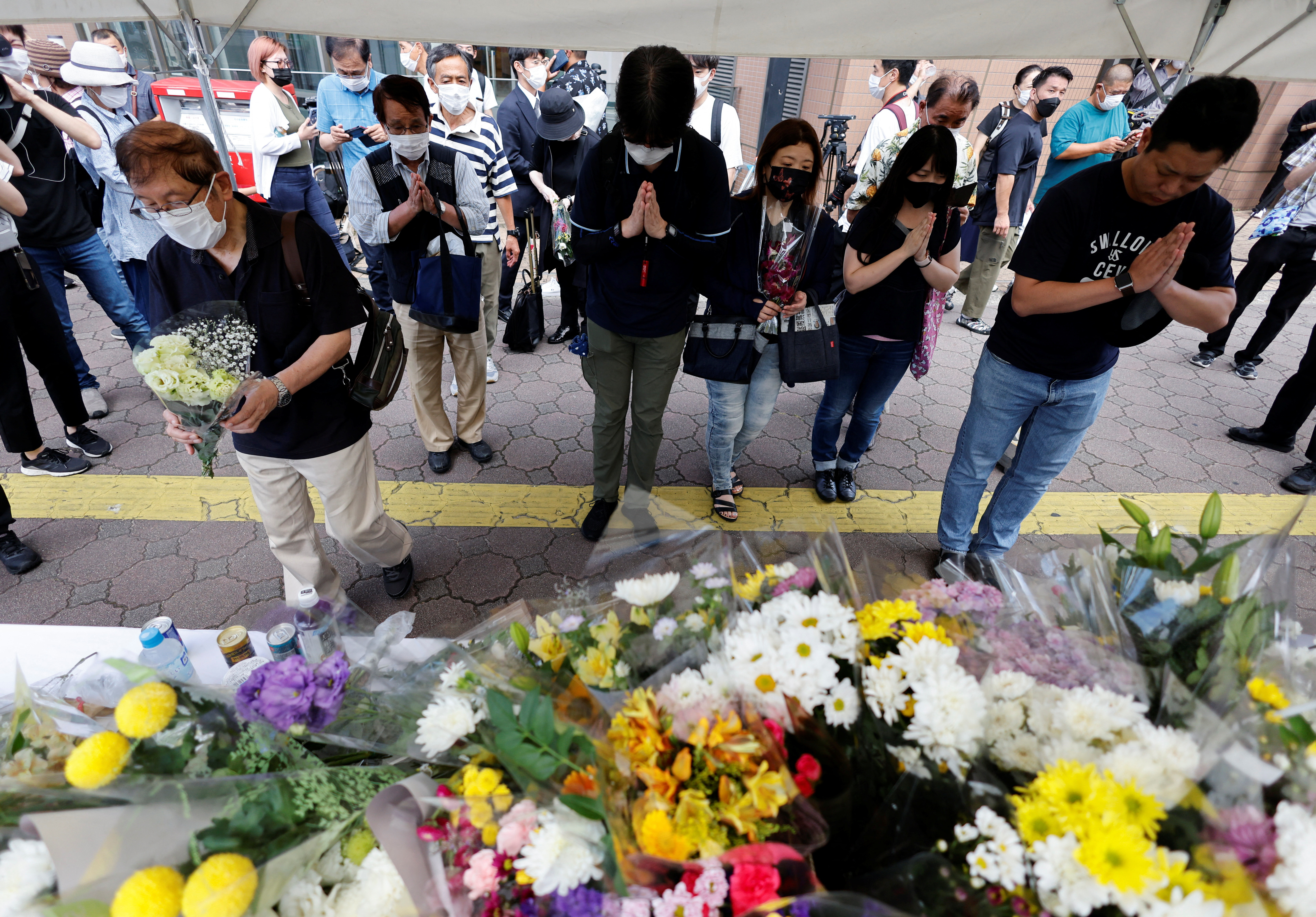 Personas dejan flores en homenaje a Abe (REUTERS/Issei Kato)