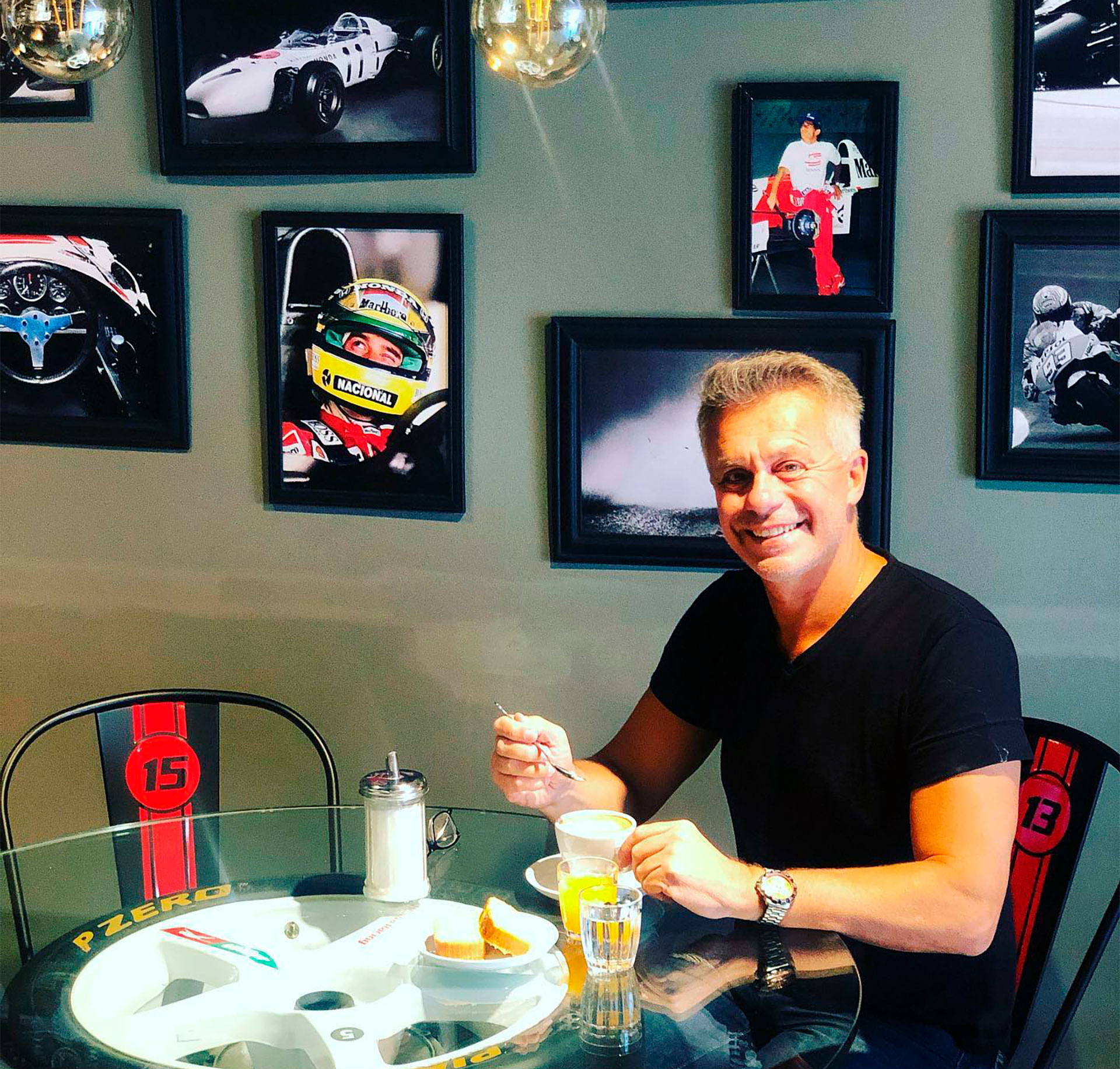 Rosso disfrutando de un café en su bar temático de automovilismo. En la pared se advierten dos cuadros de Senna (@rossovictorruben)