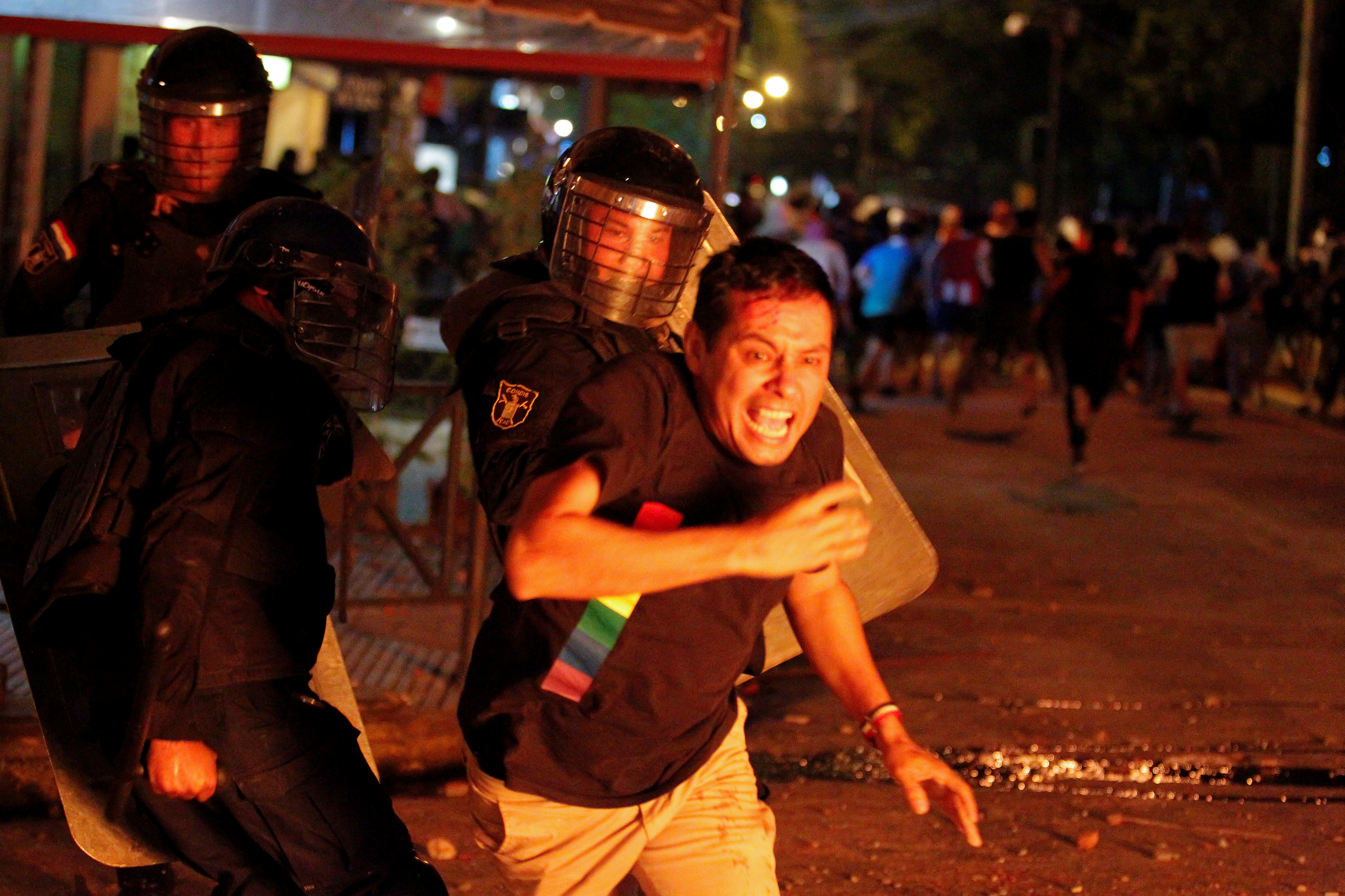 Policías persiguen a los manifestantes en Paraguay (César Olmedo/Reuters)