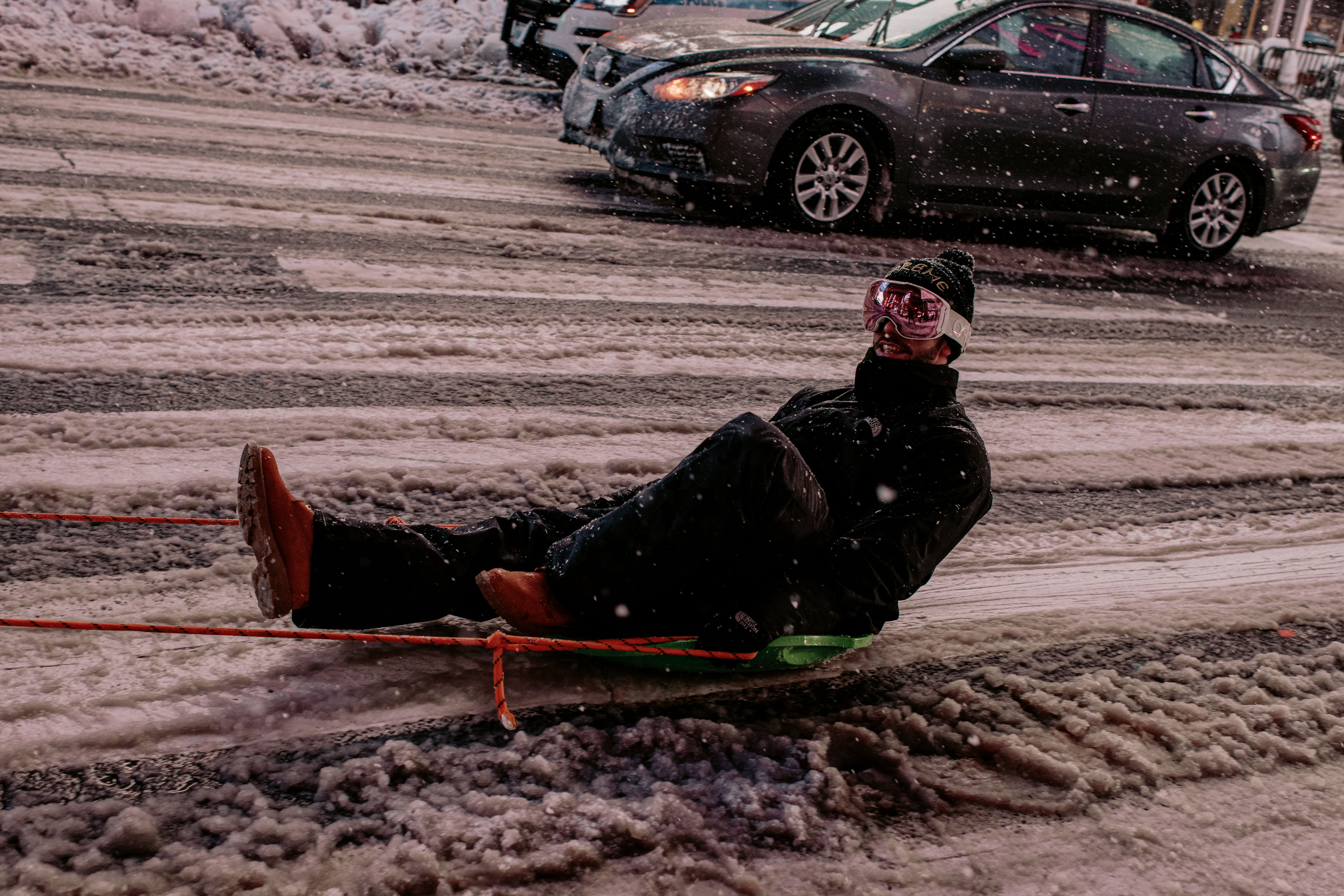 Un hombre es llevado en un trineo atado a un camión mientras la nieve sigue cayendo en Times Square (Scott Heins/Getty Images/AFP)