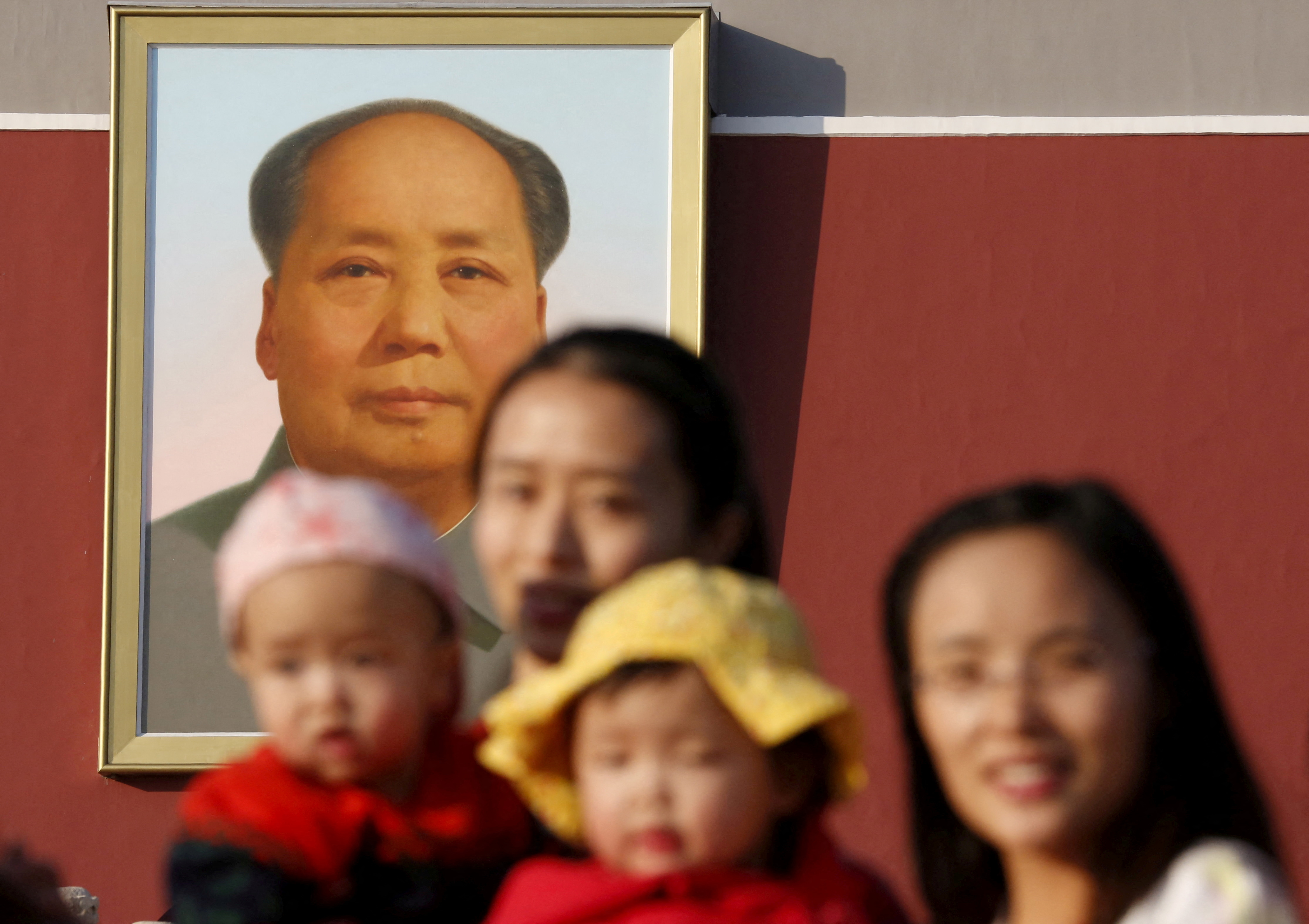 Dos mujeres posan con sus bebés delante del retrato de Mao Zedong en Tiananmen Gate (REUTERS/Kim Kyung-Hoon/File Photo/Archivo)