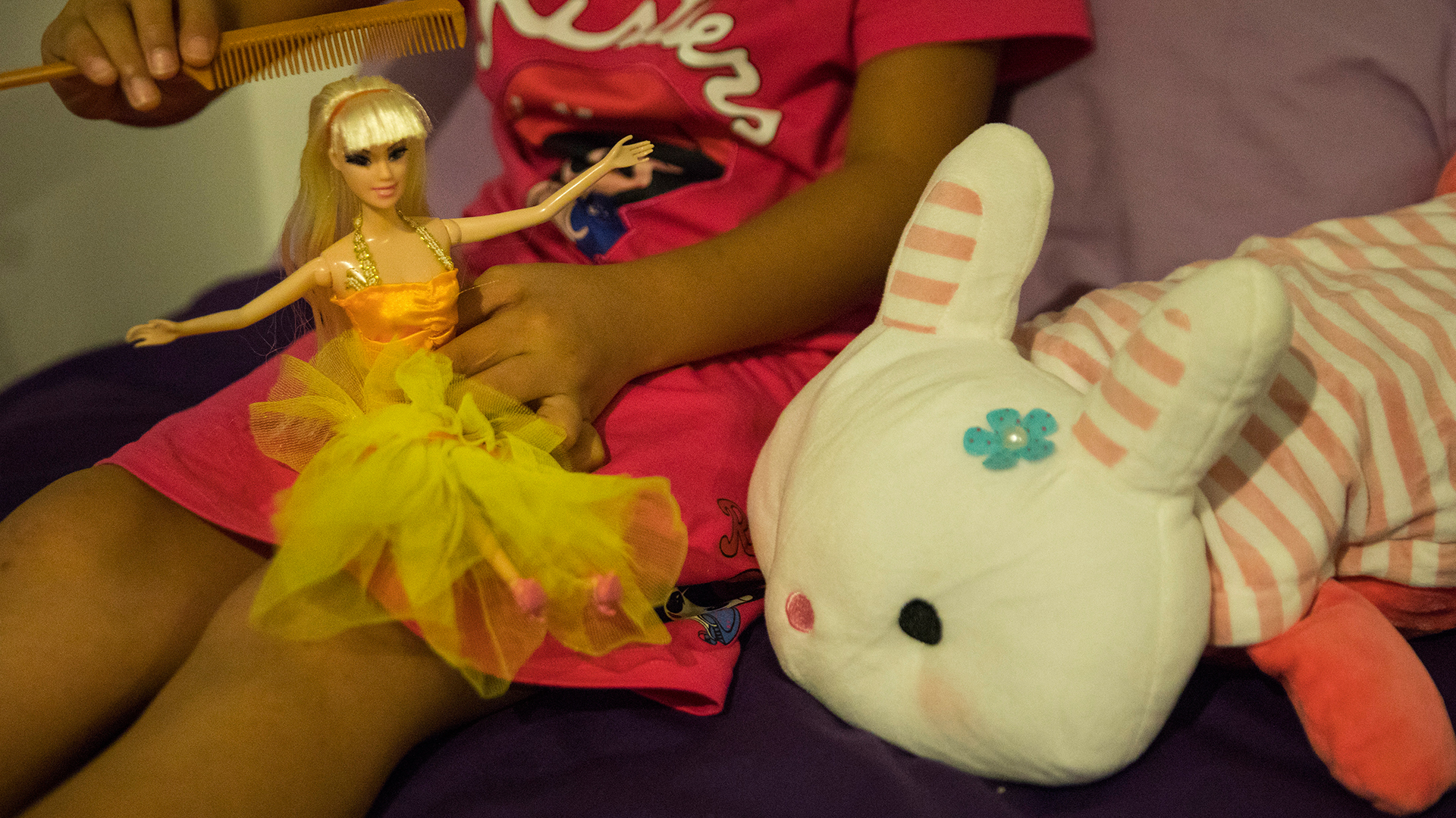 Cuidado. Una niña de 8 años peina el cabello de una muñeca (Paula Bronstein/The Washington Post)