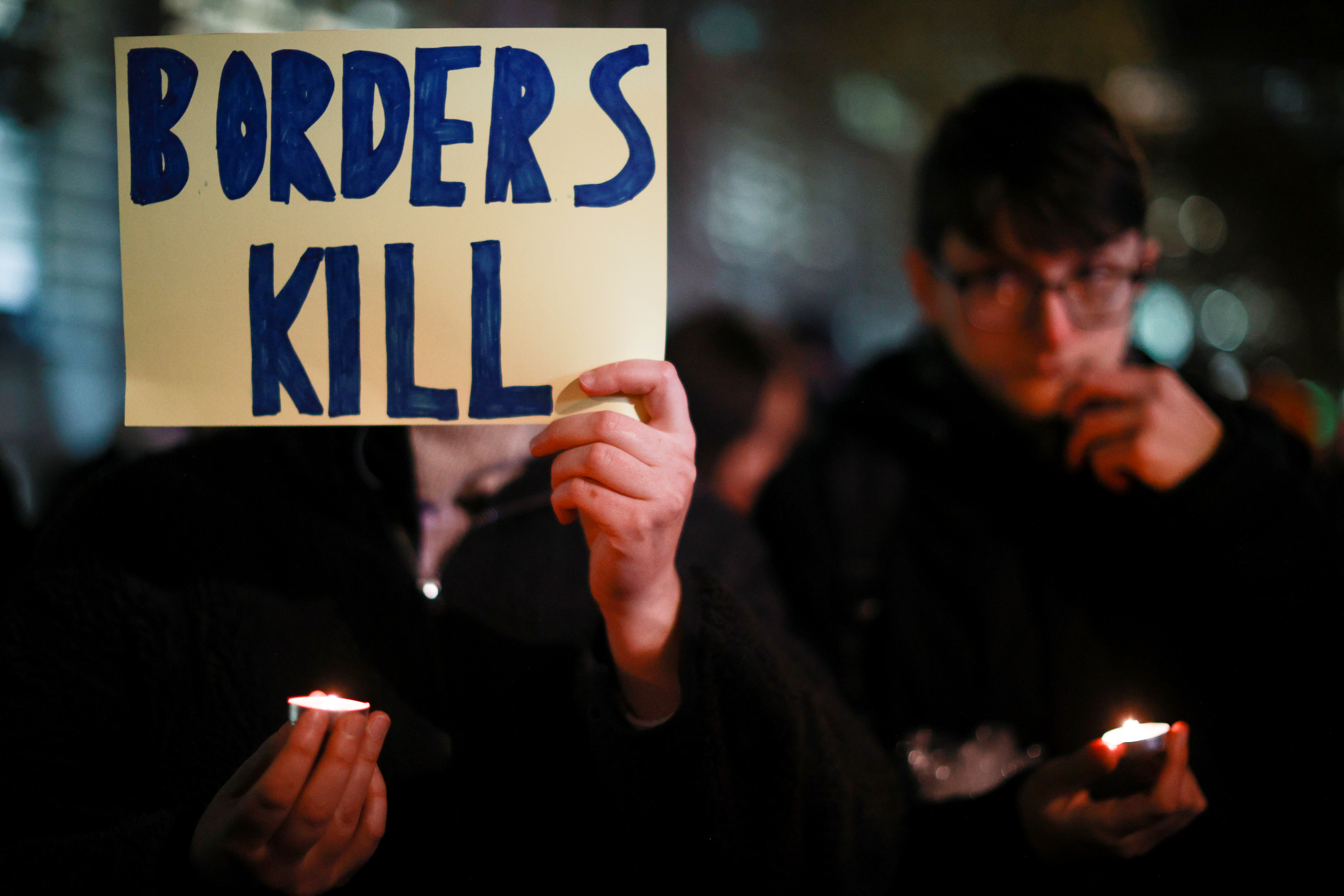 Una persona sostiene un cartel que lee "Las fronteras matan" mientras los manifestantes se manifiestan frente al Ministerio del Interior contra las muertes por migración, en Londres, Gran Bretaña. REUTERS / Hannah McKay
