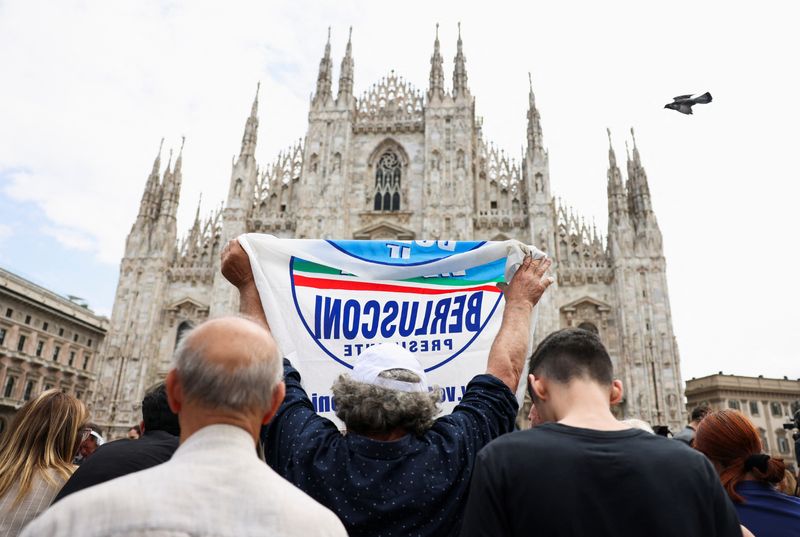 Un hombre sostiene una bandera del partido de Berlusconi (REUTERS/Claudia Greco)