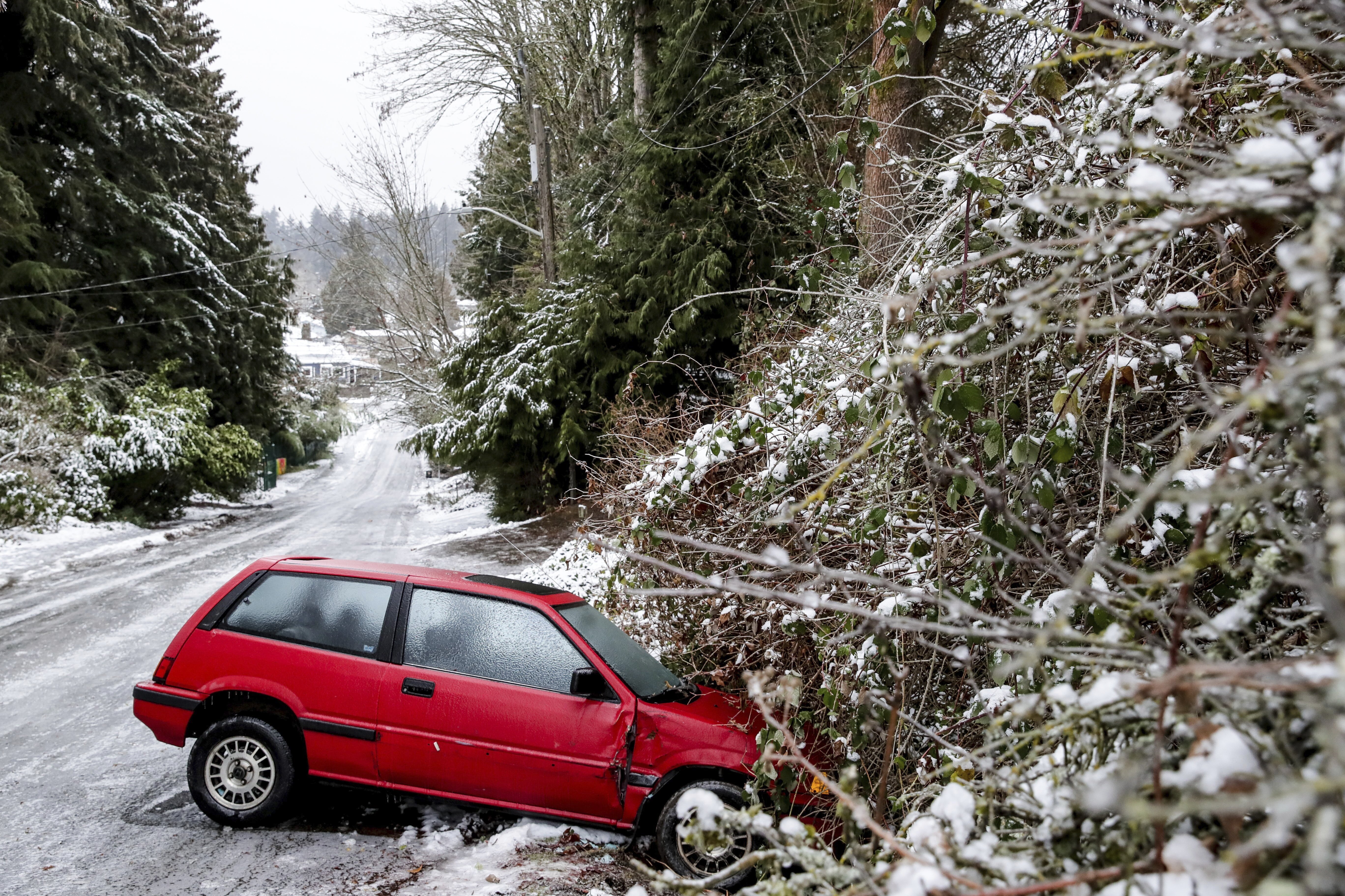 Un auto abandonado debido a las peligrosas condiciones de la carretera el viernes 23 de diciembre de 2022 en Seattle (Kevin Clark/The Seattle Times via AP)
