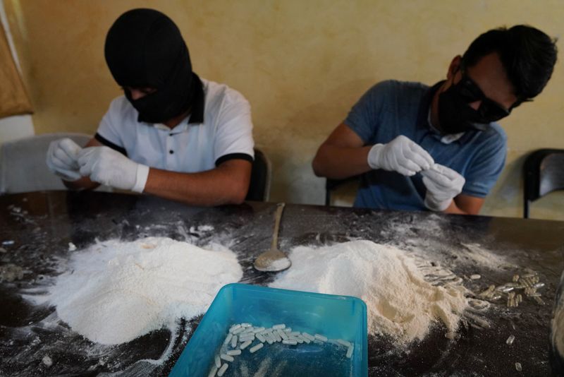 Miembros del Cártel de Sinaloa preparan cápsulas con metanfetamina en una casa de seguridad en Culiacán, México. 4 de abril, 2022. Acompaña a Reporte especial MEXICO-DROGAS-CHAPITOS REUTERS/Alexandre Meneghini