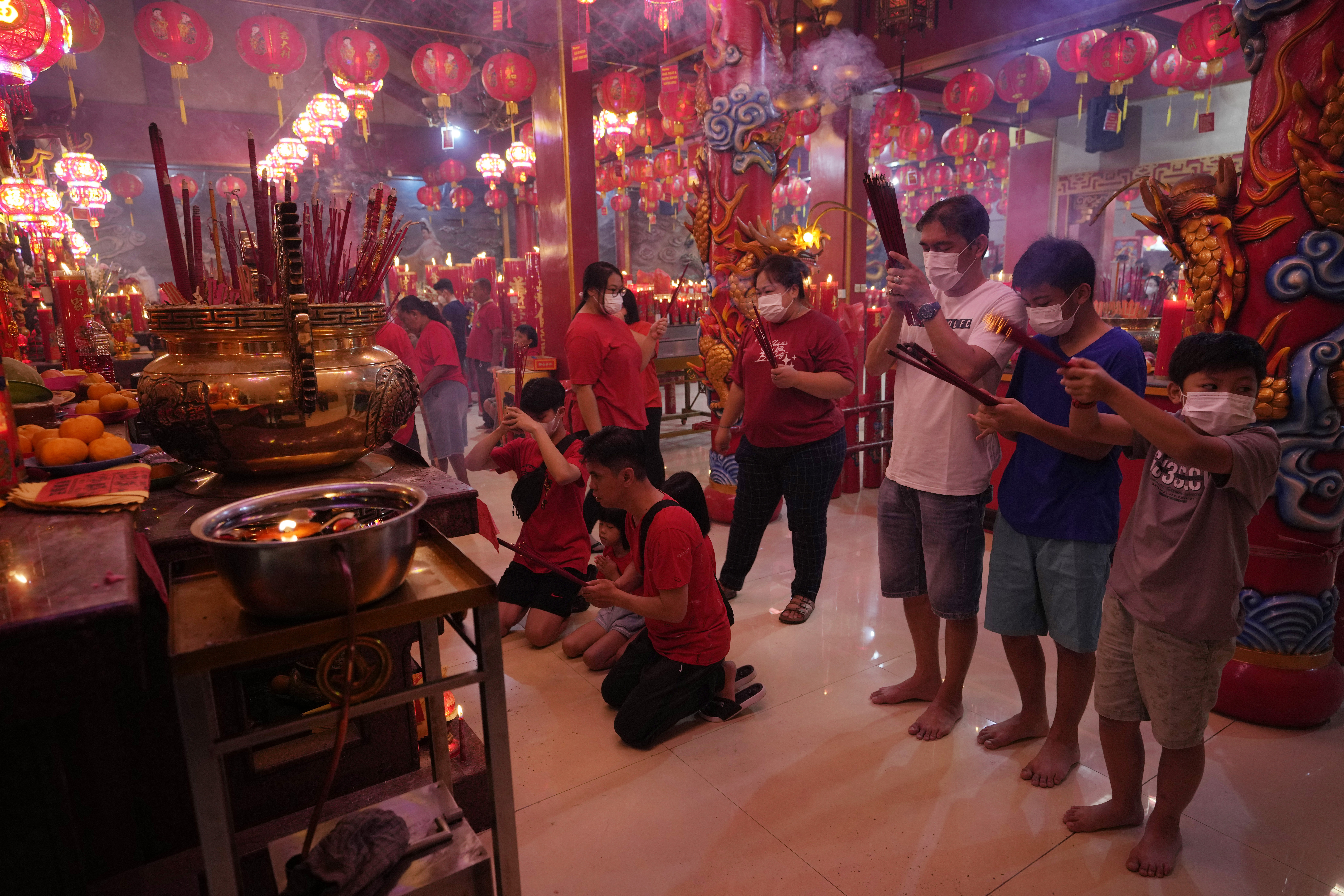 Worshipers wearing face masks offer prayers at the Hok Lay Kiong Temple in Bekasi, Indonesia, Sunday, Jan. 22, 2023. The Lunar New Year kicked off the Year of the Rabbit according to the Chinese zodiac.  (AP Photo/Achmad Ibrahim)