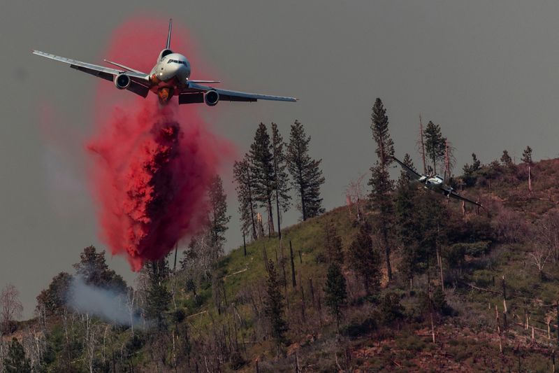Un avión de extinción de incendios lanza retardante de llamas en una ladera para controlar el incendio de Oak mientras arde cerca de Darrah en el condado de Mariposa, California. REUTERS/Carlos Barria