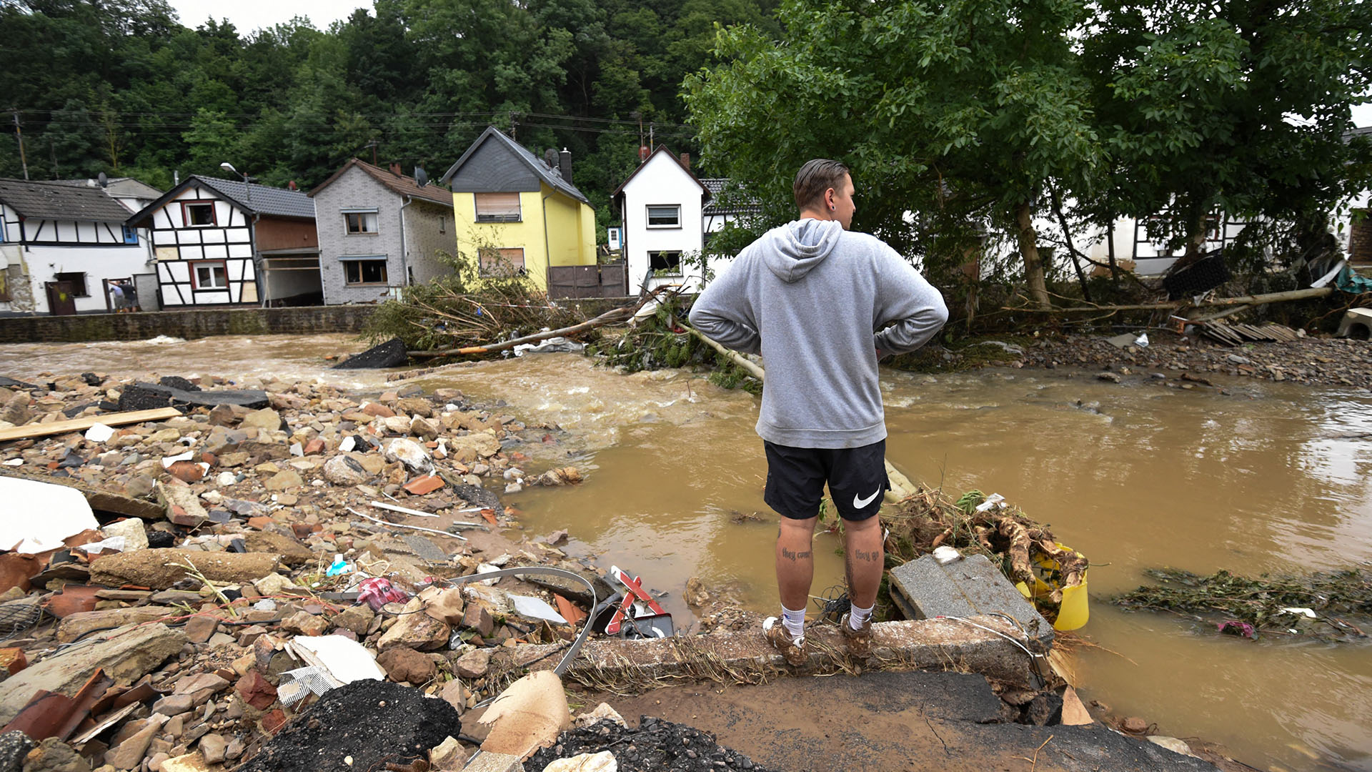 Una foto tomada el 16 de julio de 2021 muestra a un hombre parado en una intersección inundada cerca del río Erft en Iversheim cerca de Bad Muenstereifel, en el oeste de Alemania