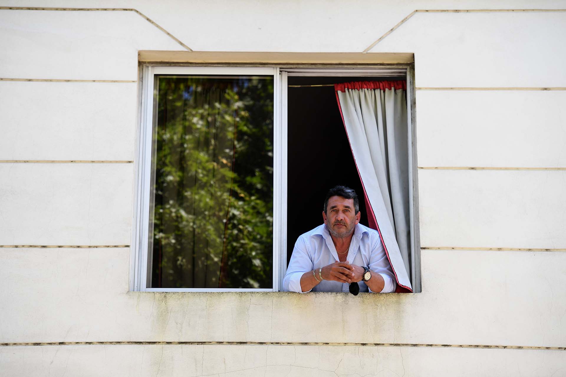 Daniel se asoma desde la ventana de la habitación de un hotel en Once, que pudo alquilar con 11 mil pesos