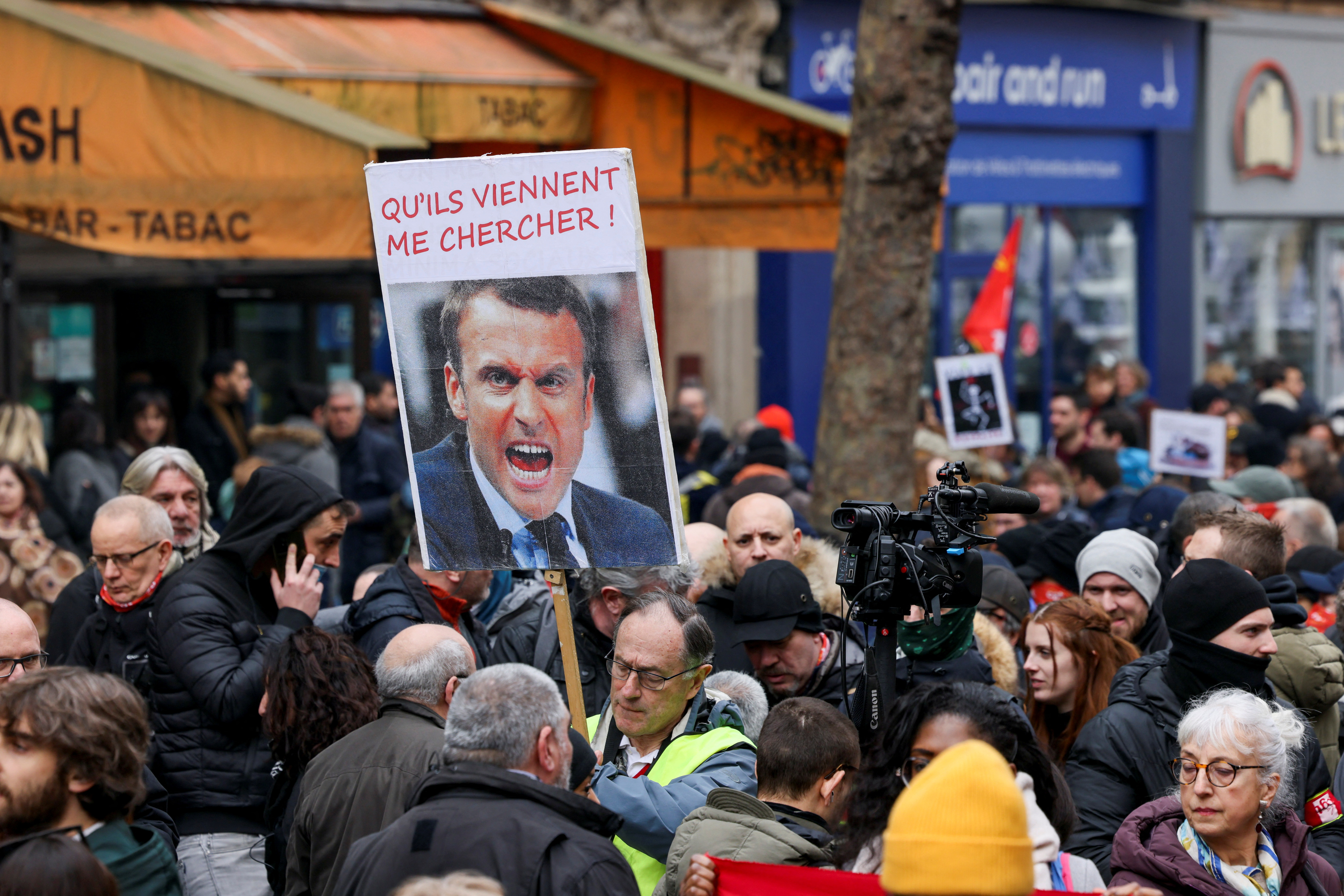 Una persona sostiene un cartel con una imagen del presidente francés, Emmanuel Macron, durante una manifestación contra el plan de reforma de las pensiones del gobierno francés como parte del cuarto día de protestas nacionales, en París, Francia, 11 de febrero de 2023. El cartel dice: '¡Que vengan a por mí! REUTERS/Yves Herman