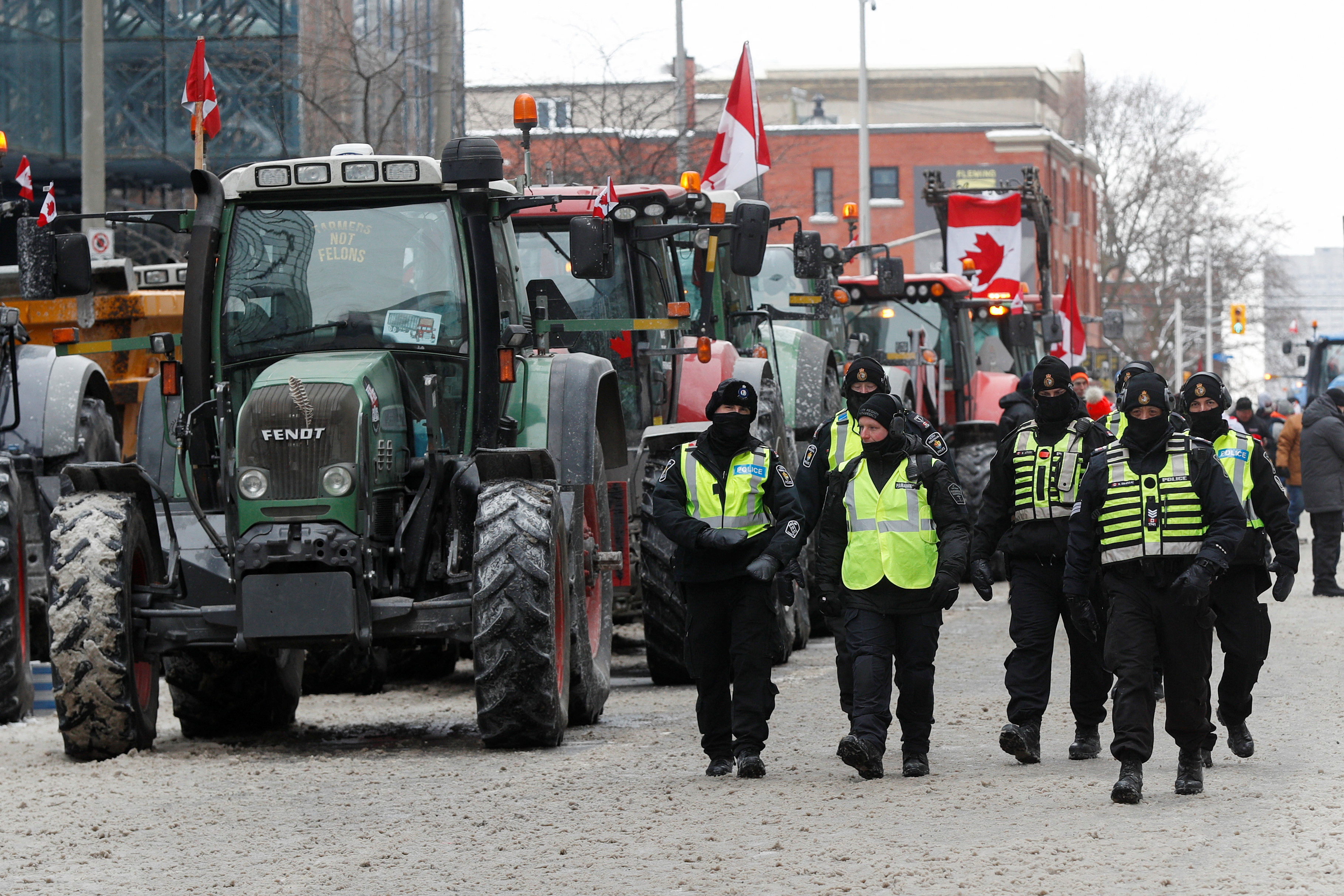 Los agentes de policía pasan junto a los tractores estacionados, mientras los camioneros y los simpatizantes continúan protestando por los mandatos de vacunación contra la enfermedad del coronavirus (COVID-19), en Ottawa, Ontario, Canadá, el 6 de febrero de 2022. REUTERS/Lars Hagberg