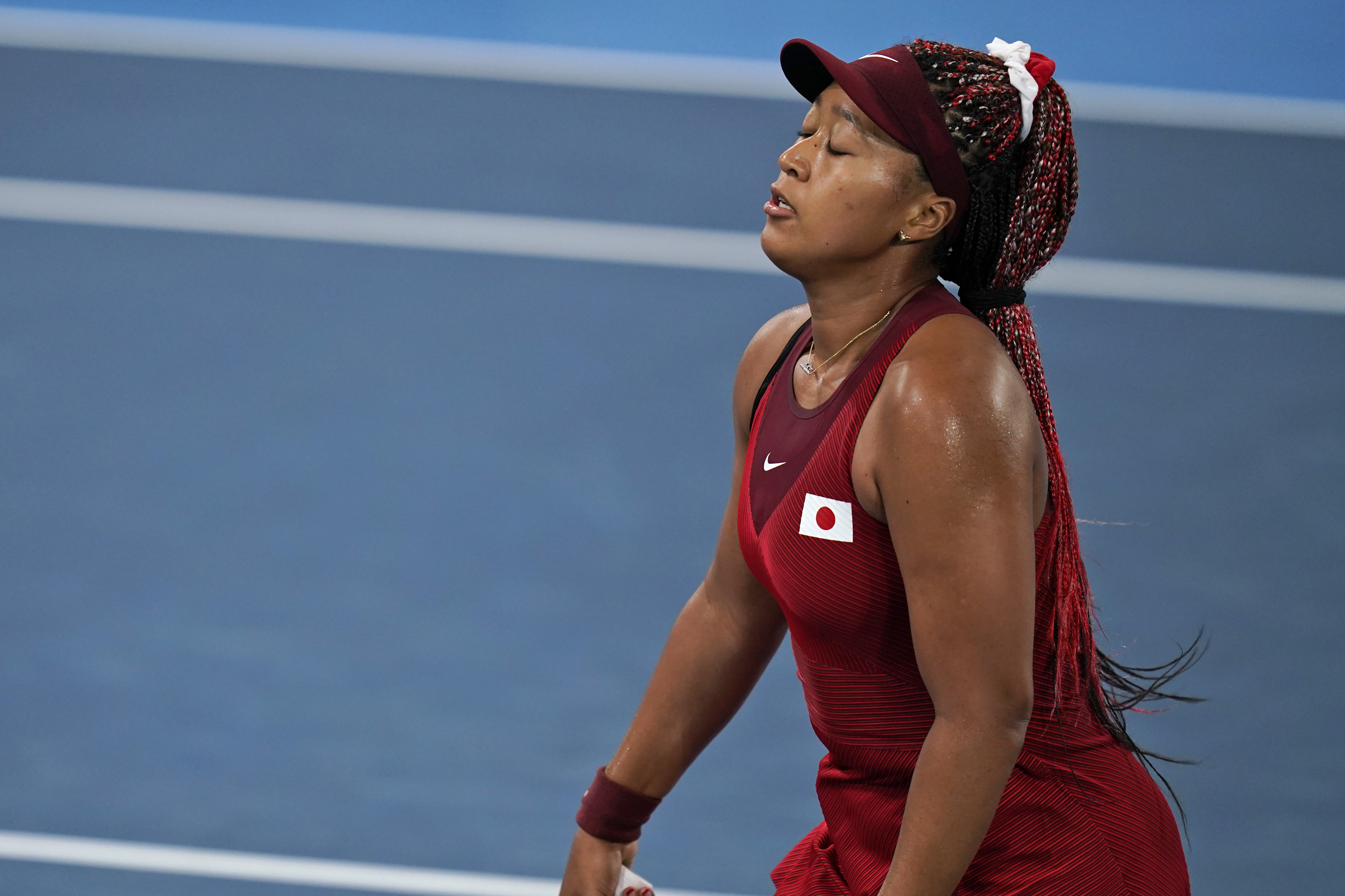 La japonesa Naomi Osaka se lamenta después de perder un punto ante la checa Marketa Vondrusova en la tercera ronda del torneo olímpico de tenis, el martes 27 de julio de 2021, en Tokio. (AP Foto/Seth Wenig)