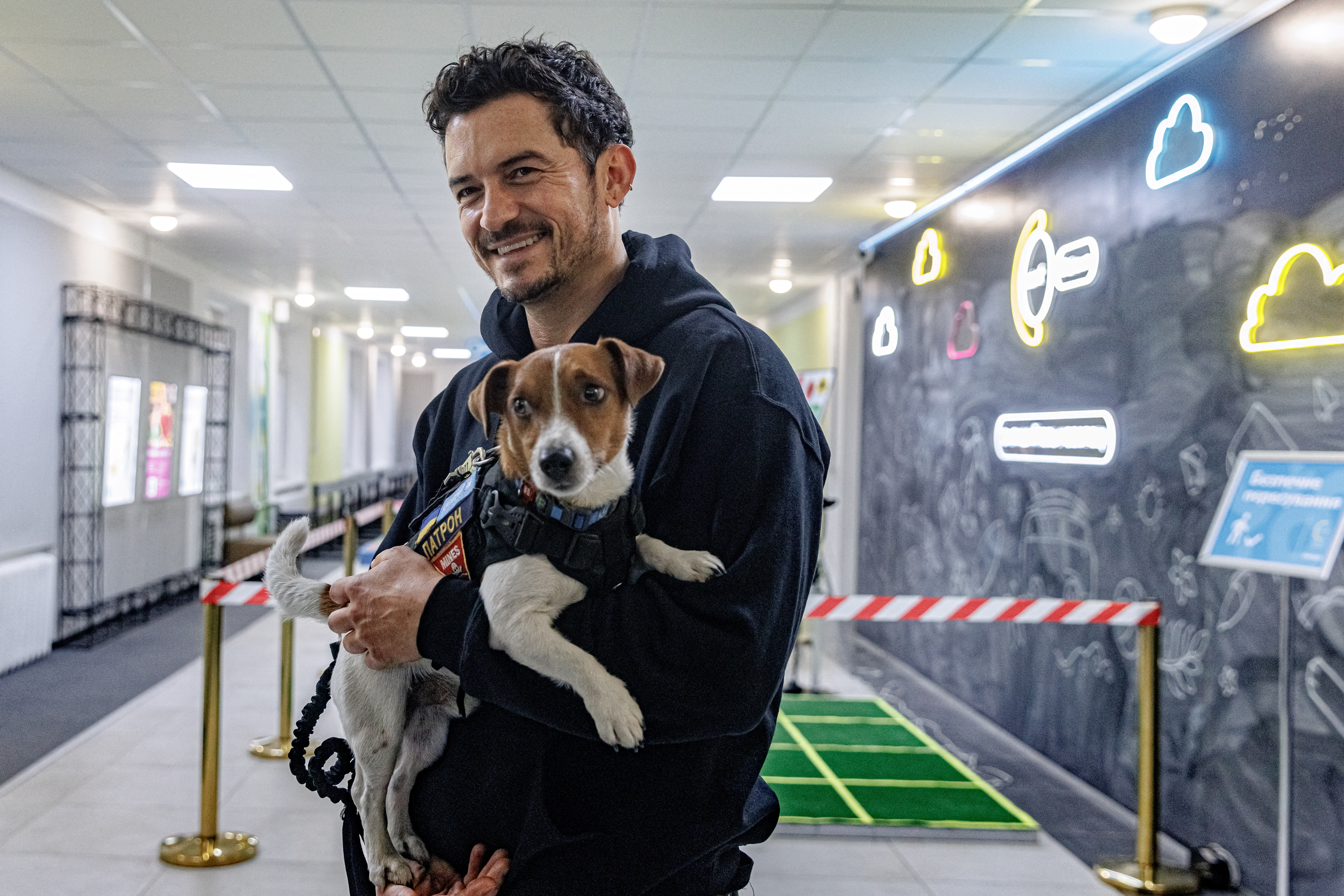 Bloom sostiene al perro Patrón, perro detector y mascota del Servicio Estatal de Emergencias de Ucrania en Kiev (UNICEF/Skyba/REUTERS)