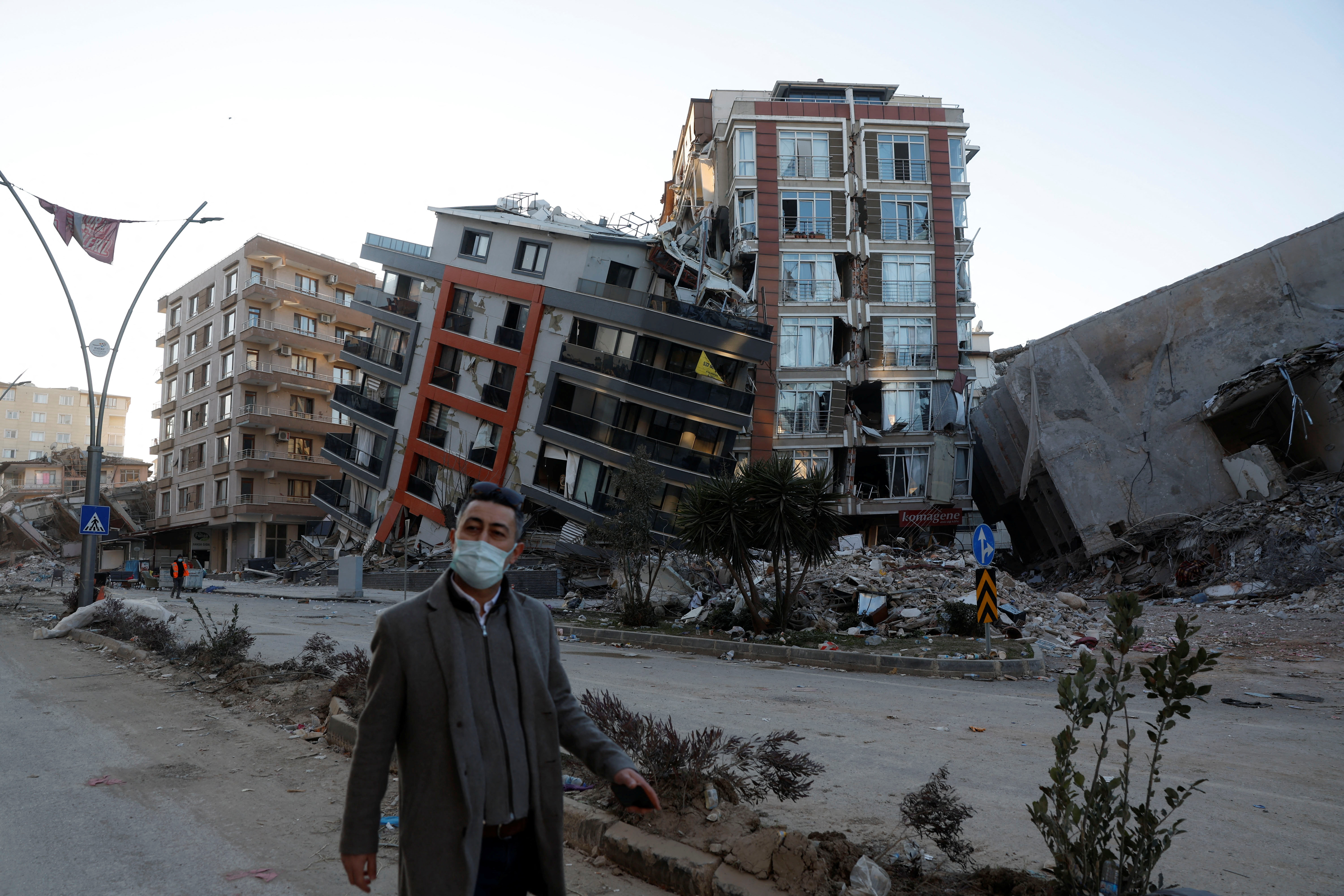 Un hombre camina delante de edificios semiderrumbados tras un terremoto mortal en Hatay, Turquía, 15 de febrero de 2023. REUTERS/Clodagh Kilcoyne