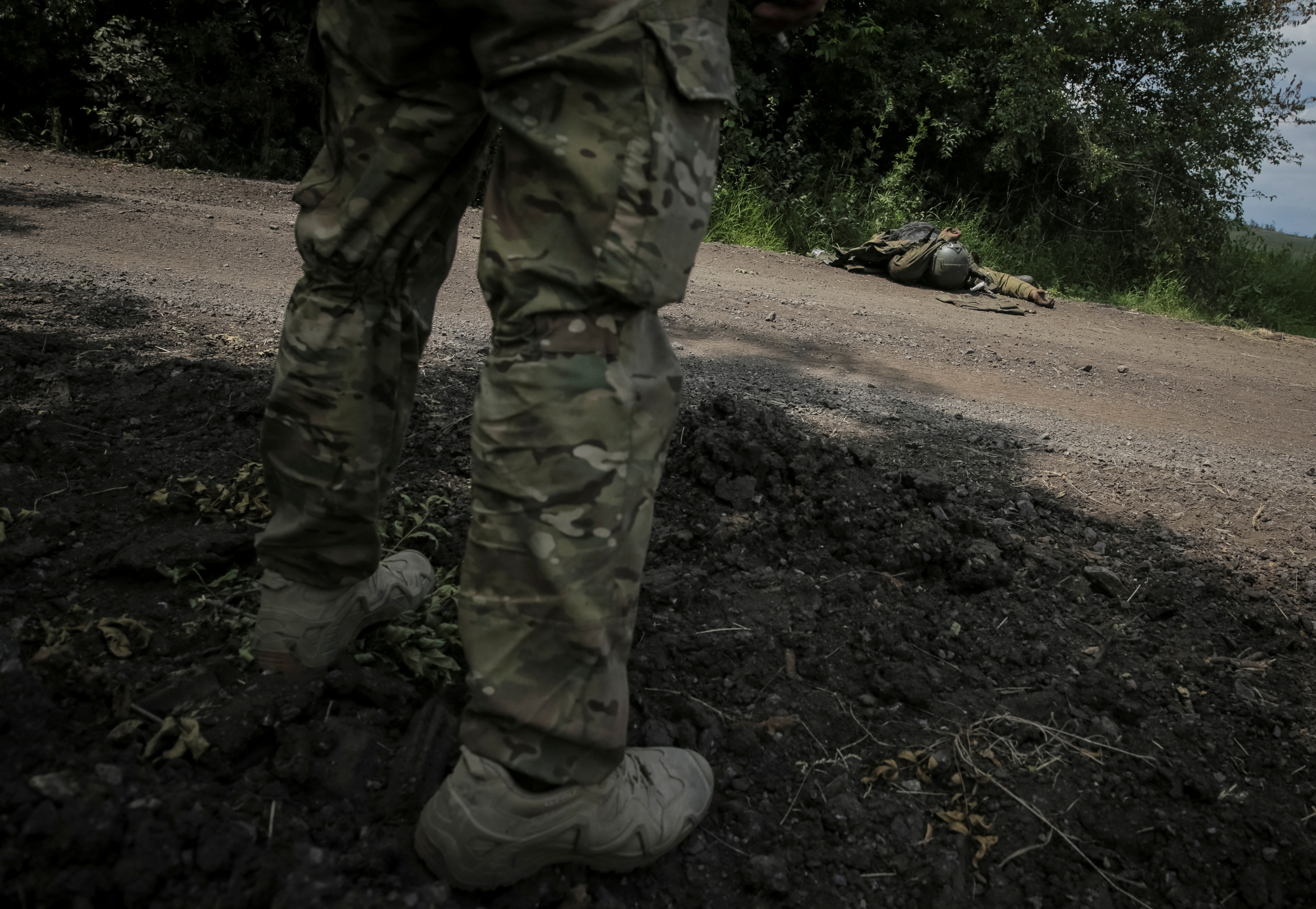 MATERIAL SENSIBLE. Un miembro del servicio ucraniano se encuentra cerca del cuerpo de un soldado ruso, en medio del ataque de Rusia a Ucrania, cerca de la línea del frente en el pueblo recién liberado Storozheve en la región de Donetsk, Ucrania 14 de junio 2023. REUTERS/Oleksandr Ratushniak