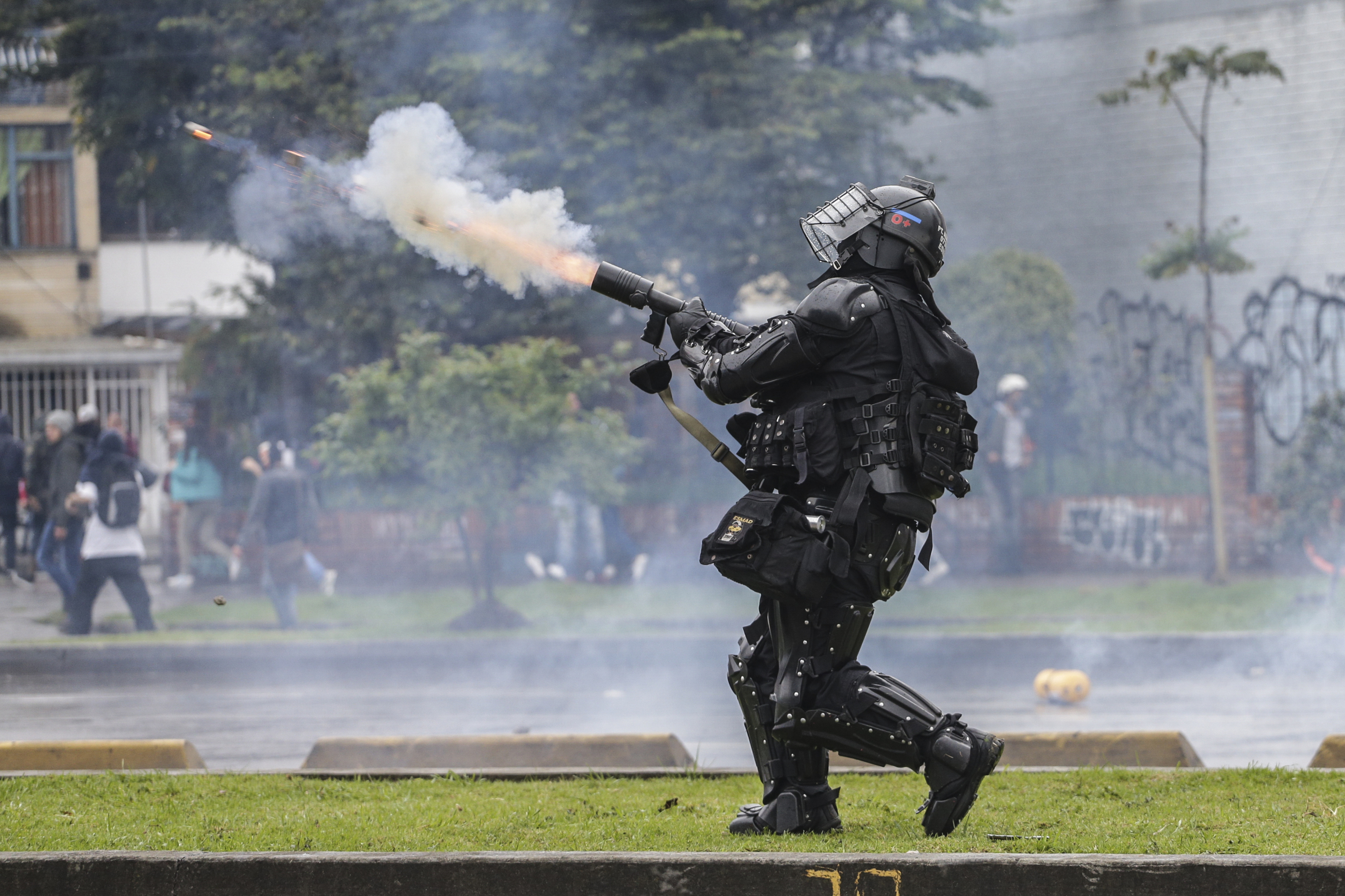 Un policía dispara gases lacrimógenos a manifestantes en Bogotá, Colombia. (AP Foto / Ivan Valencia)