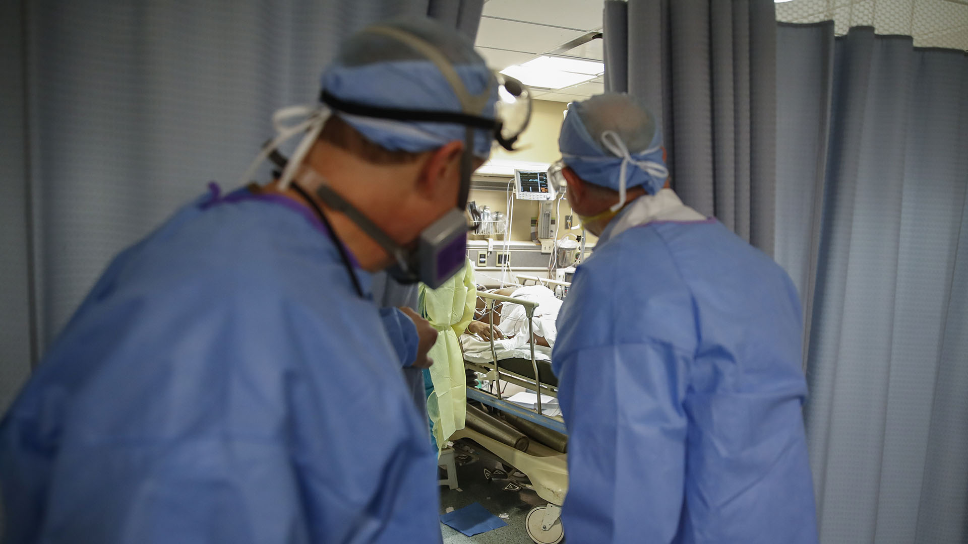 El Dr. Anthony Leno, Director de Medicina de Emergencia del Hospital St. Joseph's, a la izquierda, y el Dr. James Neuendorf, Director de Medicina, a la derecha, examinan una sala de examen donde un paciente con COVID-19 sufrió un paro cardíaco y fue revivido (AP/John Minchillo)