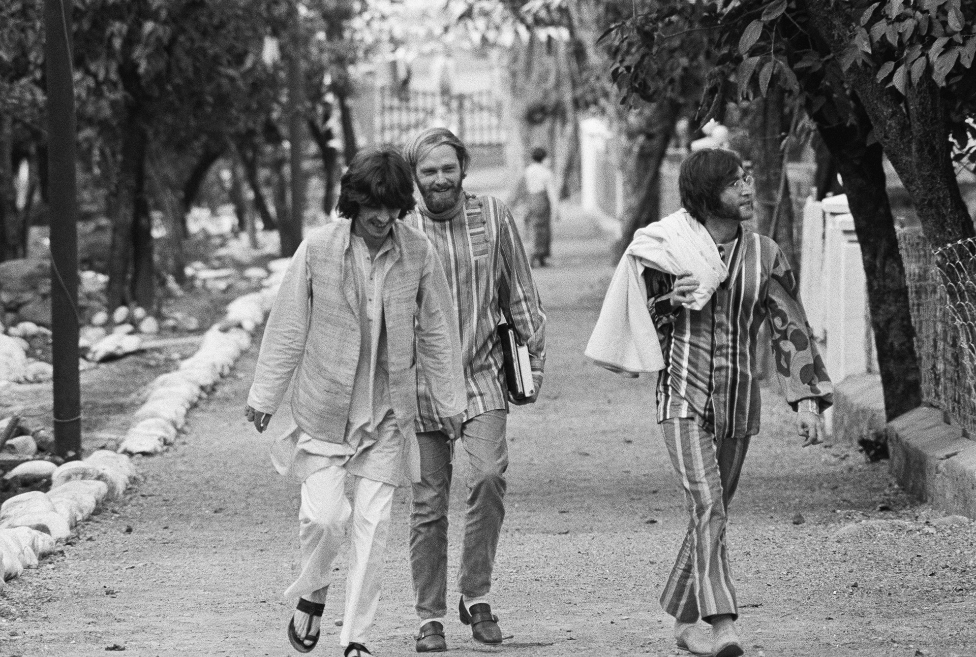 George Harrison y John Lennon, acompañados por Mike Love de los Beach Boys, paseando por una calle en Shankaracharyyanagar (Bettmann Archive)