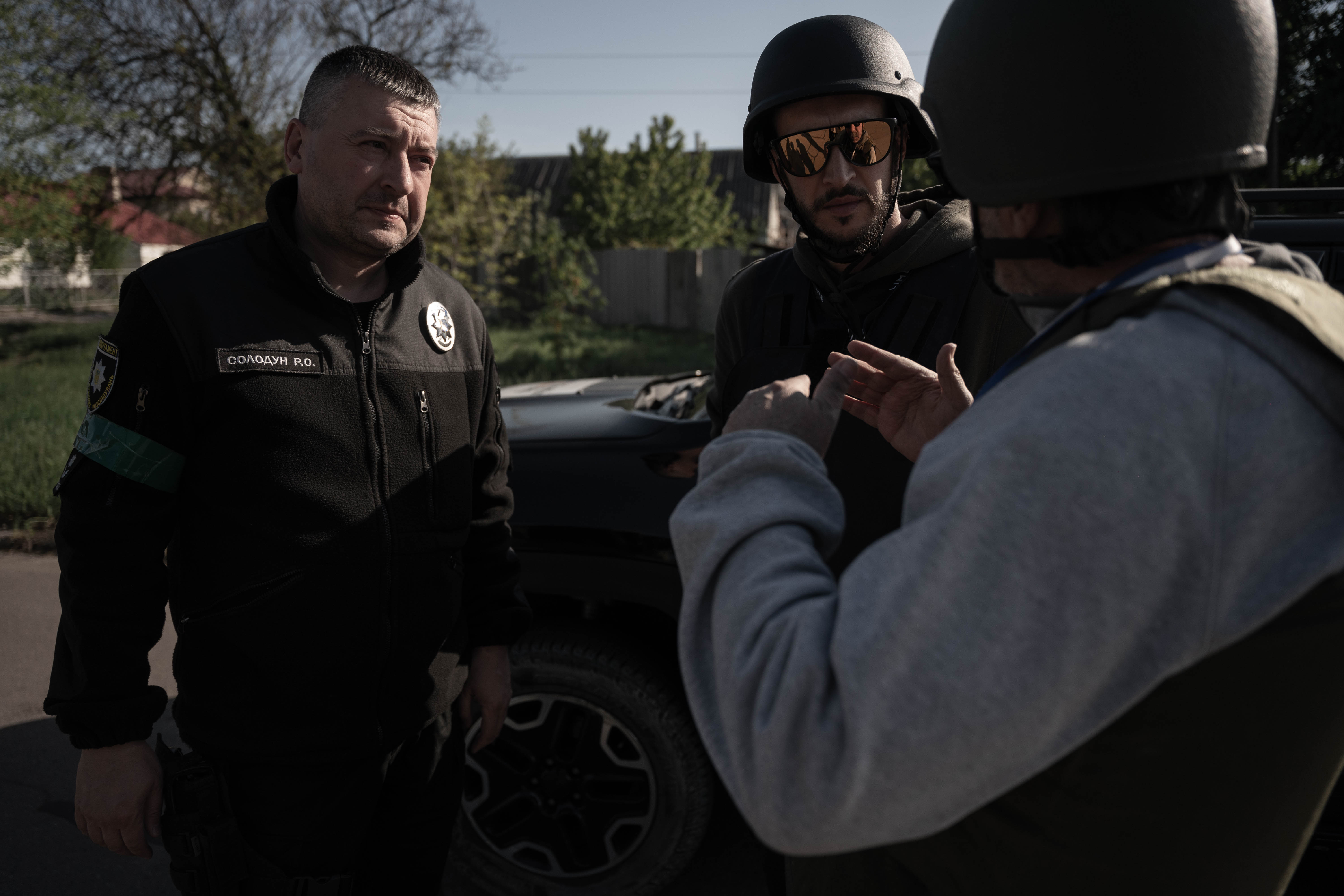 Solodun Román, teniente coronel de la Policía Nacional, el traductor Andrii Ovod, y Román Lejtman, enviado especial de Infobae, dialogan en una calle de Kramatorsk. (Foto: Franco Fafasuli)