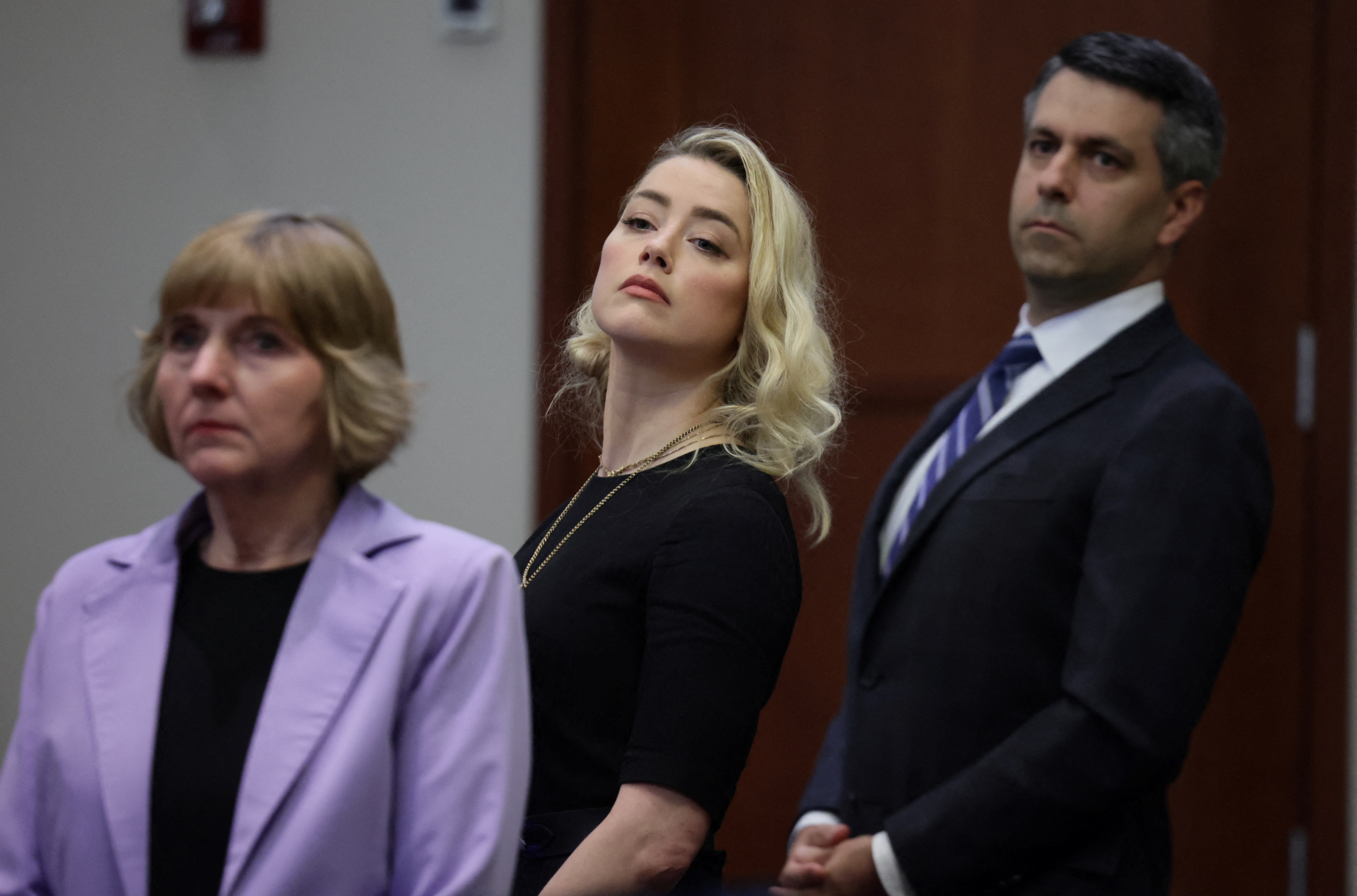 La actriz Amber Heard y sus abogados Elaine Bredehoft y Benjamin Rottenborn miran hacia el jurado, justo antes de que el jurado anuncie que cree que ella difamó a su ex marido Johnny Depp el 1 de junio de 2022 (REUTERS/Evelyn Hockstein)