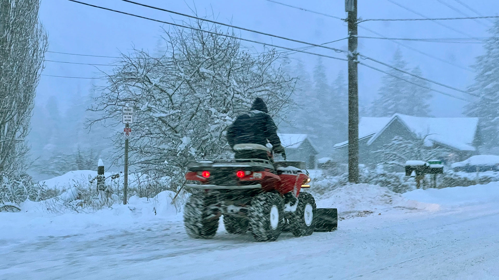 Una persona utiliza un vehículo de cuatro ruedas para quitar la nieve al noreste de Bellingham, Washington