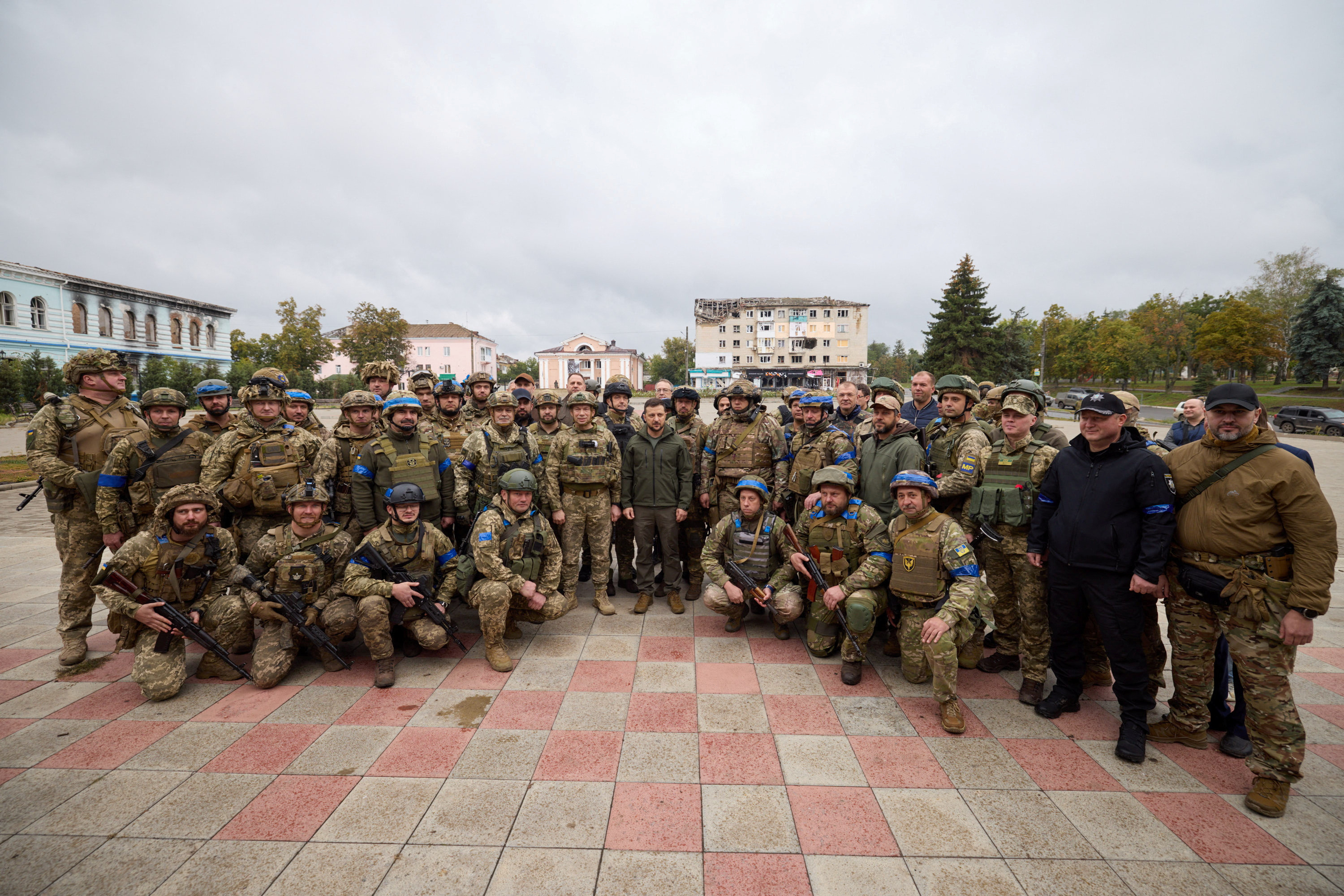Zelenskiy, posa para una foto de grupo con miembros del servicio en la ciudad de Izium recientemente liberada por las Fuerzas Armadas de Ucrania