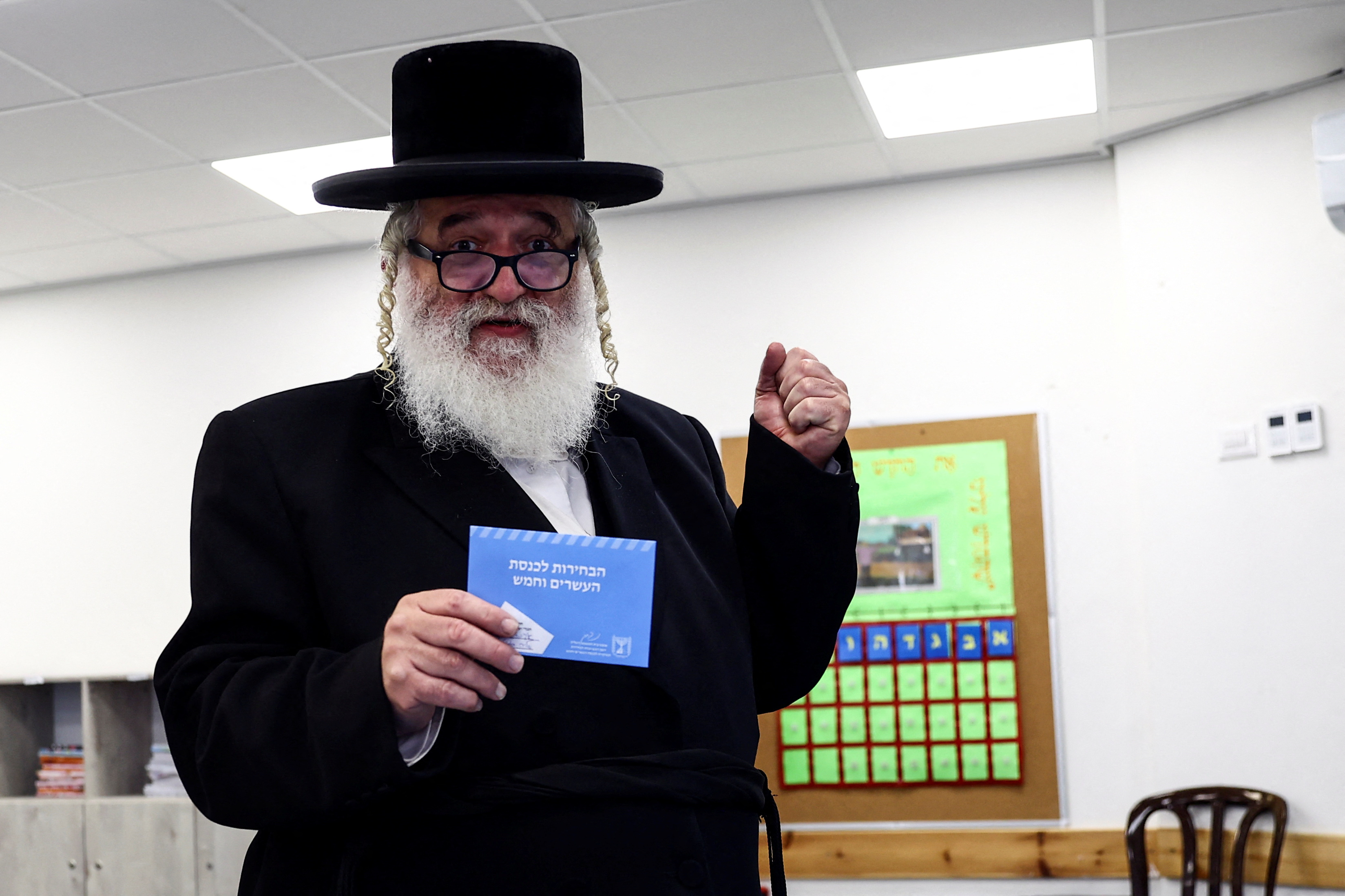 Un judío ultraortodoxo israelí sostiene un sobre con su papeleta de voto el día de las elecciones generales de Israel en un colegio electoral en Jerusalén el 1 de noviembre de 2022. REUTERS/Ronen Zvulun