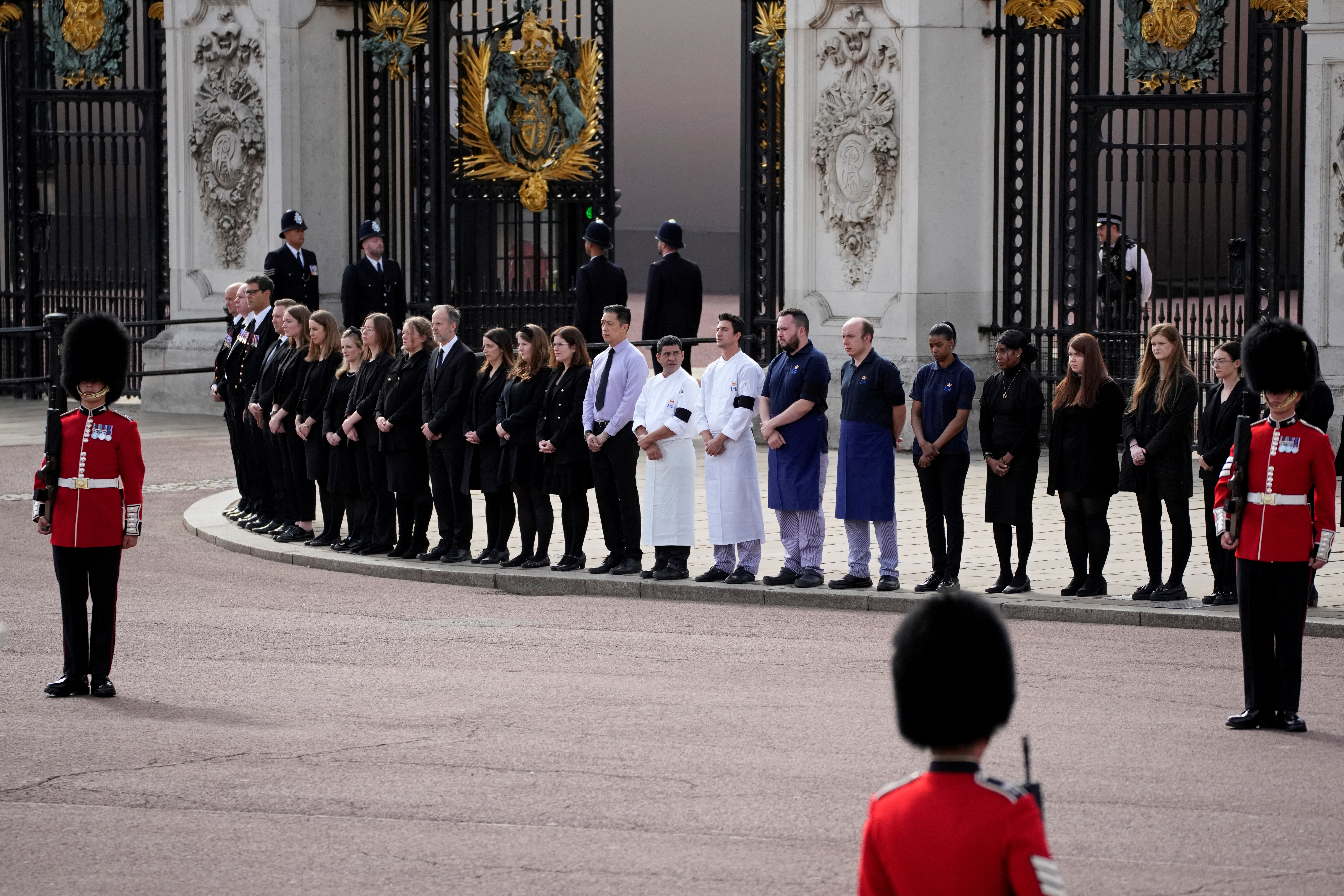 El personal del Palacio de Buckingham se para fuera de sus puertas, para rendir homenaje a la monarca. 