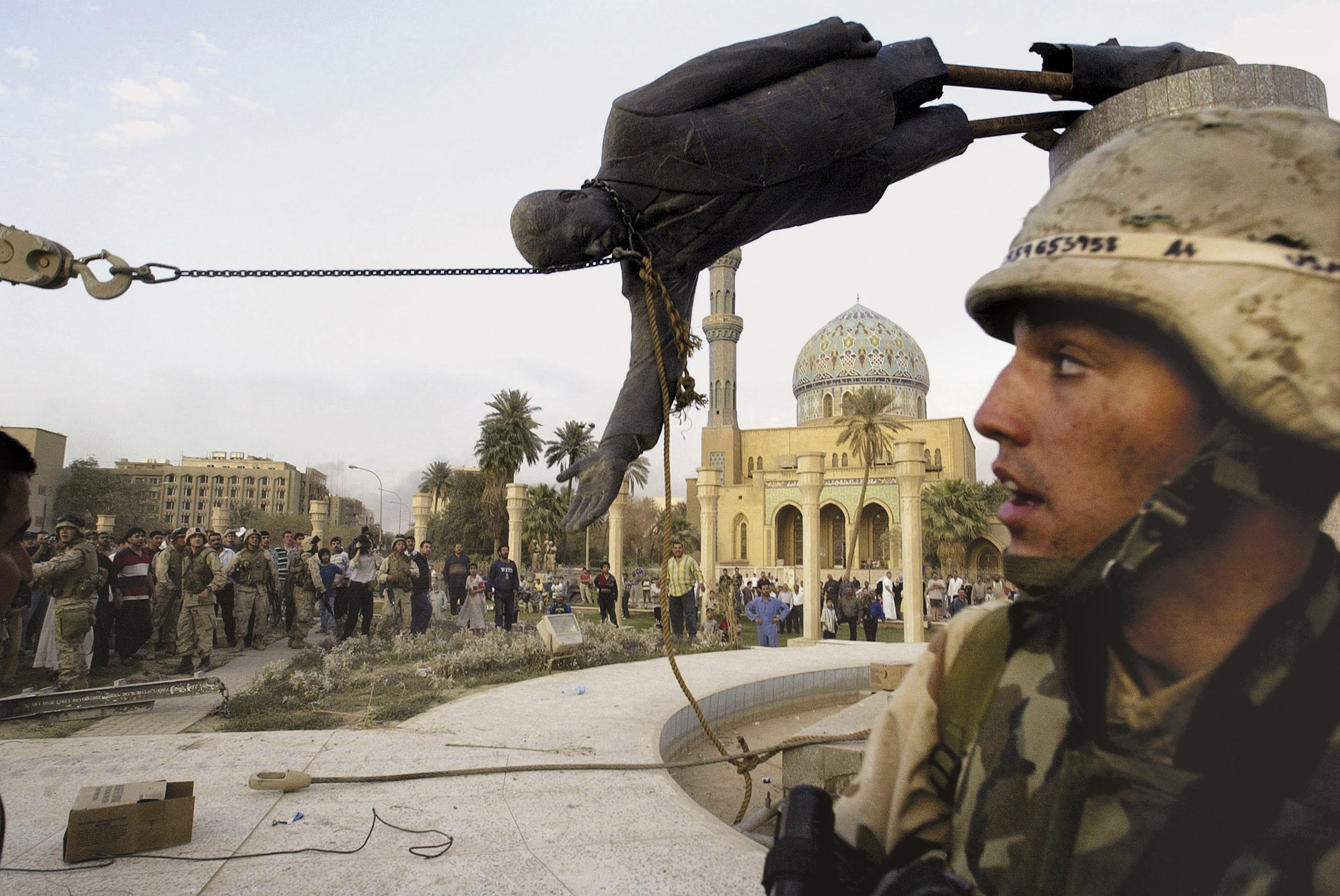 La imagen más difundida de la caída de la estatua de Saddam Hussein en 2003. Los marines había despejado el centro de la plaza para que la grúa pudiera derribarla.