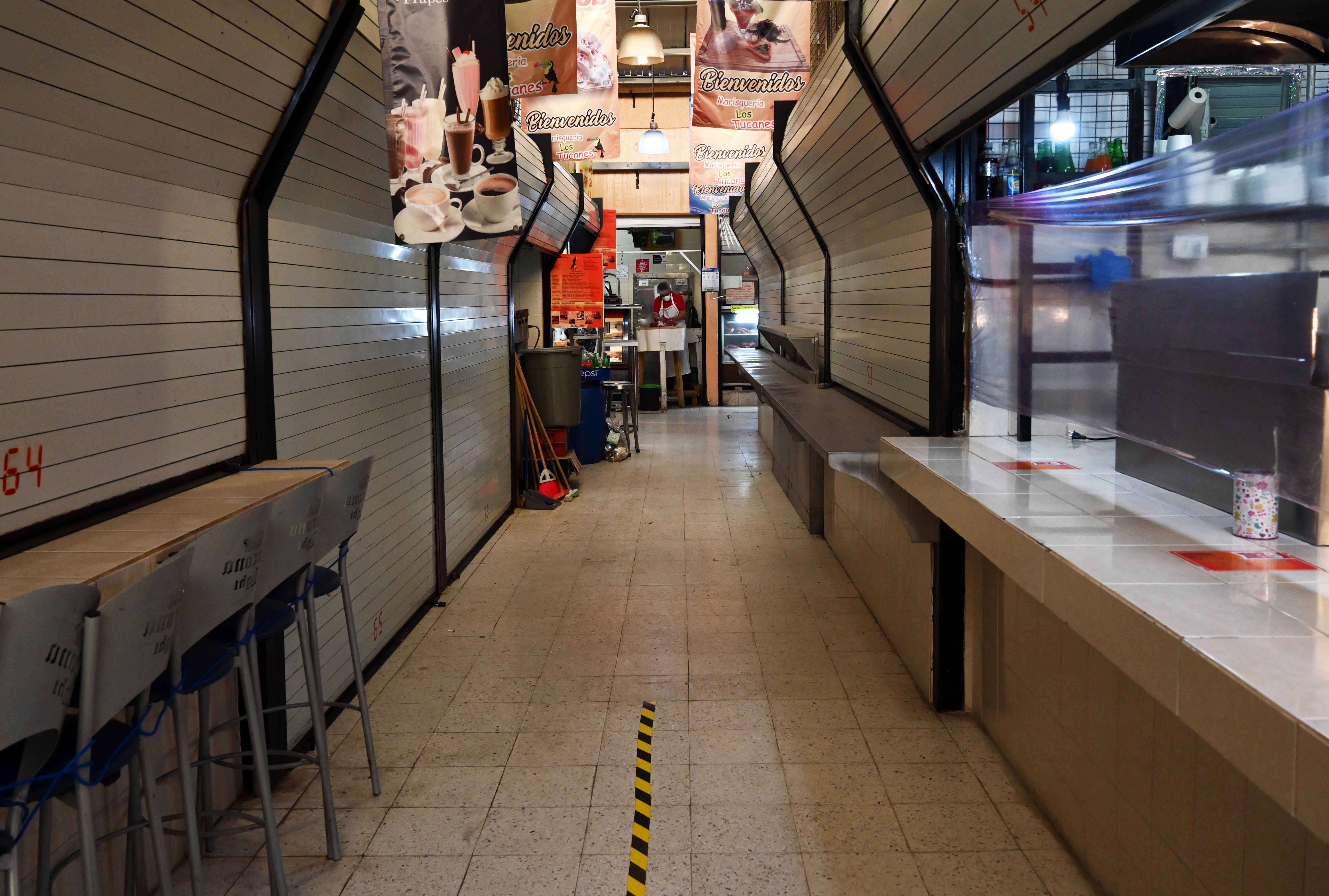 Un hombre trabaja en su carnicería, mientras que los restaurantes permanecen cerrados en un mercado popular en la Ciudad de México el 29 de junio de 2020. (Foto: RODRIGO ARANGUA / AFP)