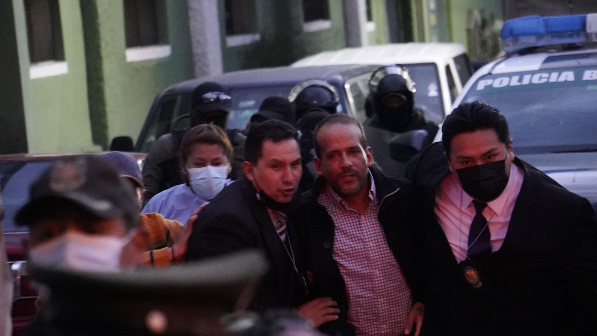 El gobernador de la región boliviana de Santa Cruz, el opositor Luis Fernando Camacho, ingresa junto a policías vestidos de civiles a las oficinas de la Fuerza Especial de Lucha contra el Crimen (Felcc) en La Paz el pasado 28 de diciembre (EFE/Javier Mamani)