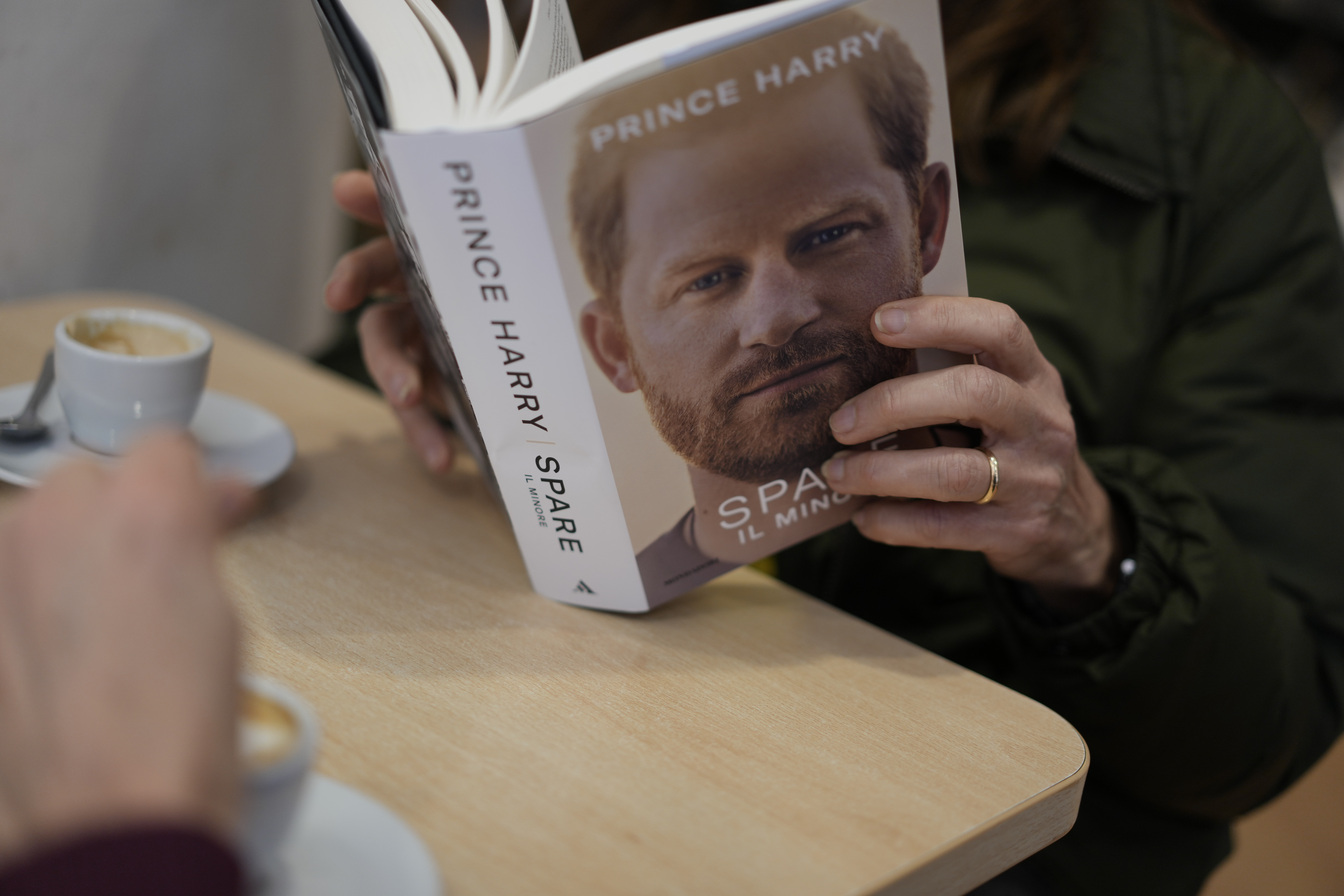 Una persona lee una copia del nuevo libro "Spare" del príncipe Enrique en una librería de Roma, el martes 10 de enero de 2023. (AP Foto/Andrew Medichini)