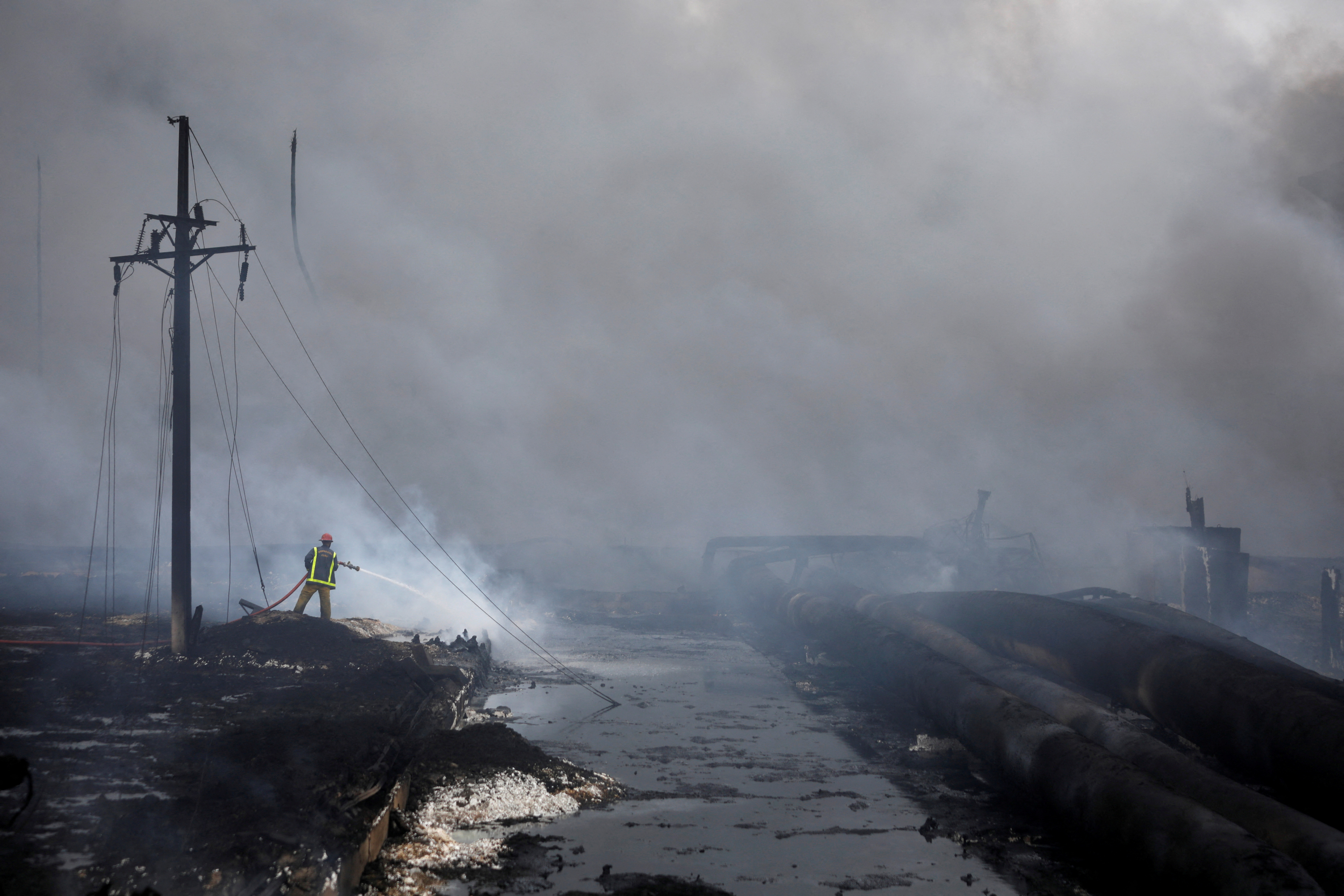 Un bombero trabaja en la zona donde explotaron los tanques (REUTERS/Alexandre Meneghini)