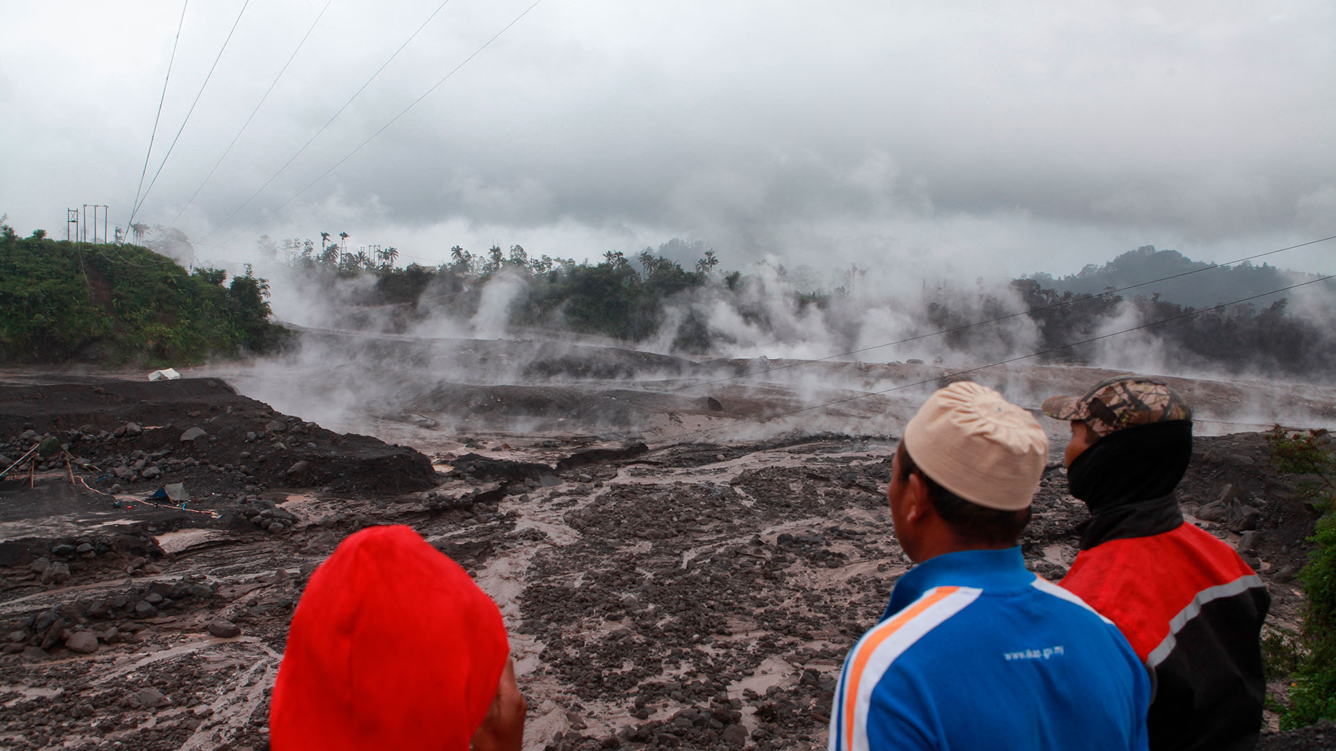 Los aldeanos observan el humo caliente del suelo luego de la erupción volcánica del Monte Semeru en Lumajang, Java Oriental, el 4 de diciembre de 2022. (Foto de PUTRI / AFP)
