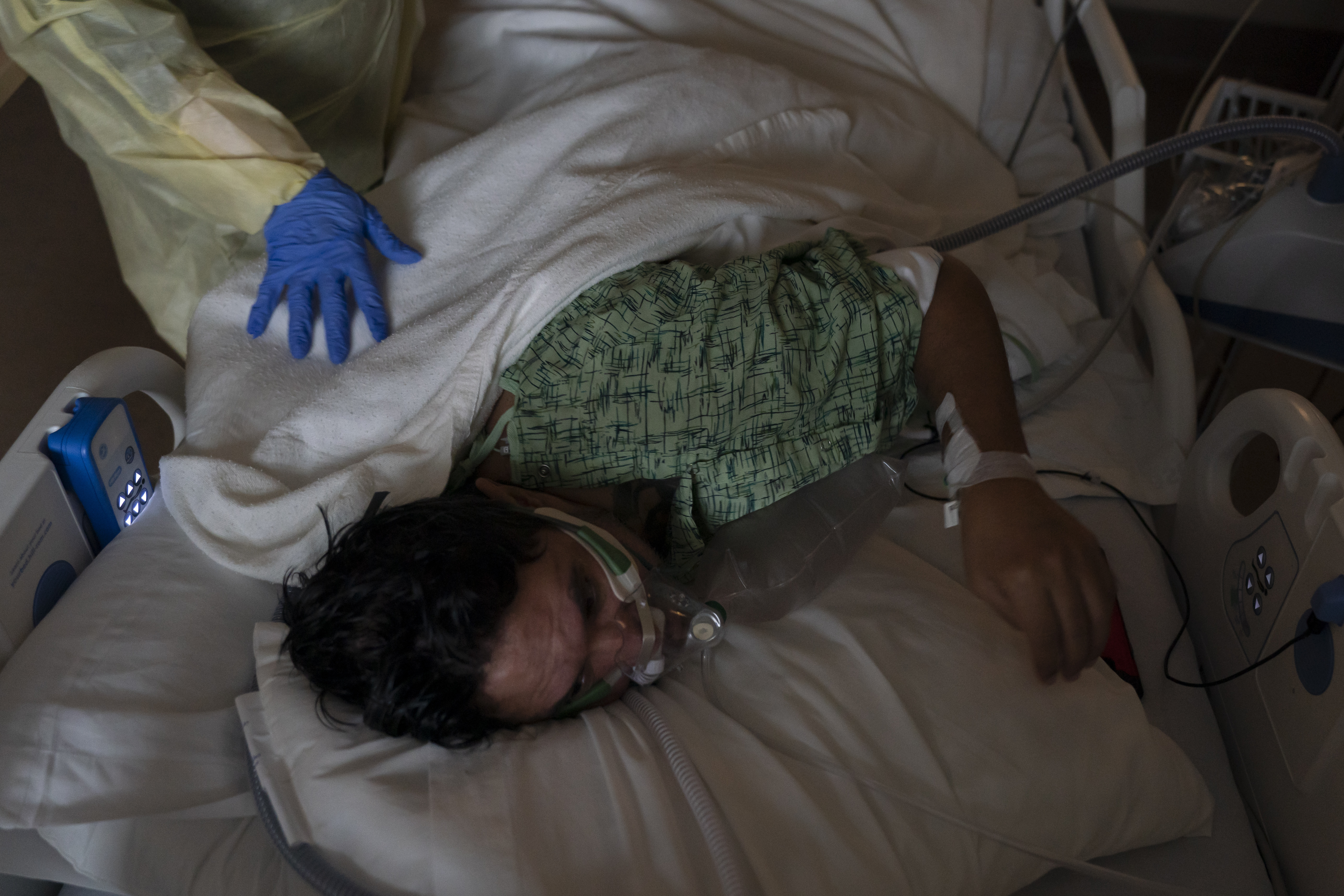ARCHIVO - El enfermero registrado Nvard Termendzhyan ayuda a Julio Valladares, de 46 años, a cambiar de posición mientras lo trata en una unidad de COVID-19 en el Centro Médico Providence Holy Cross en Los Ángeles, el 13 de diciembre de 2021. (Foto AP/Jae C. Hong, Archivo )