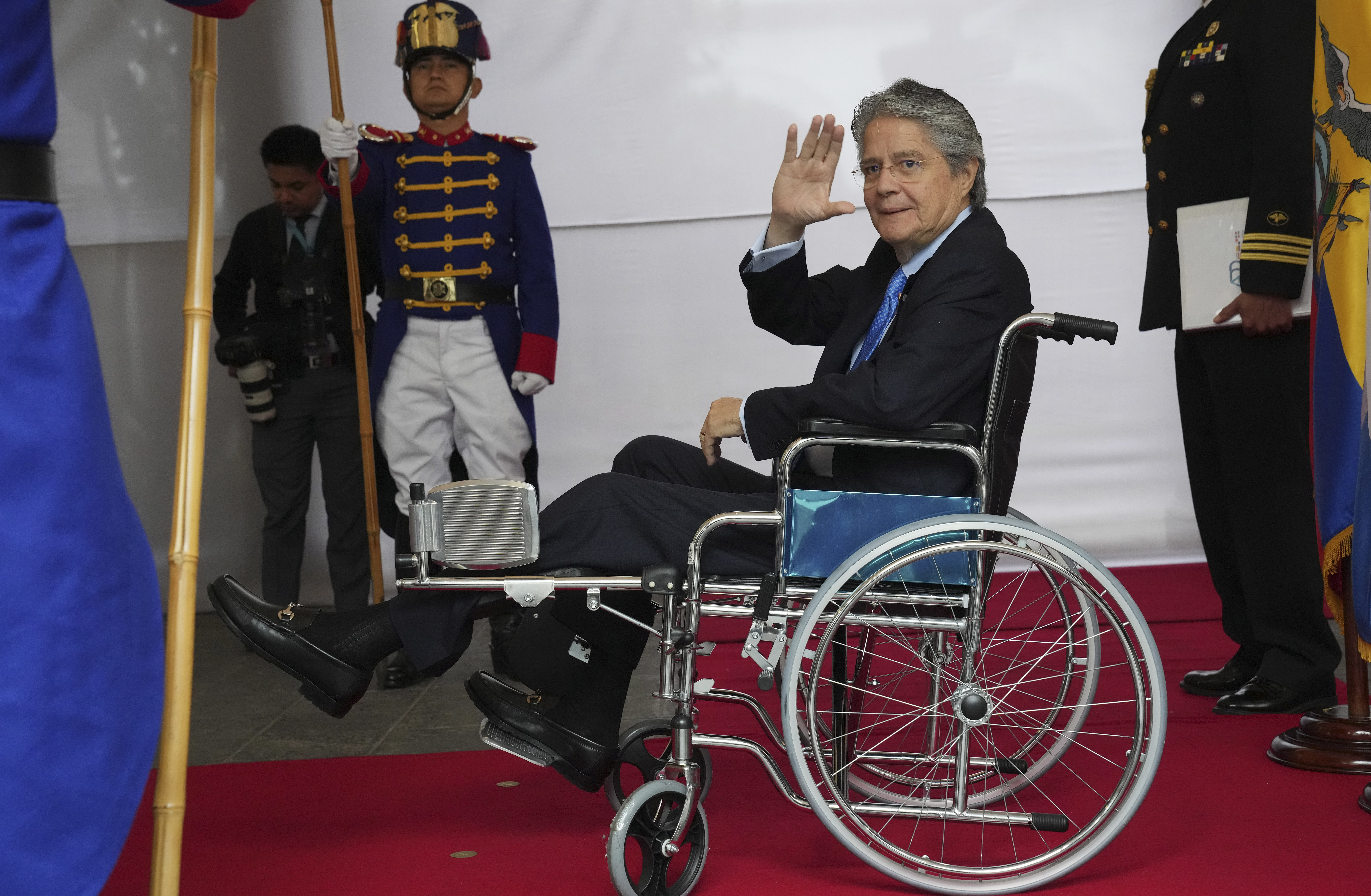 Lasso, en silla de ruedas, saluda la prensa en el palacio de gobierno (AP)