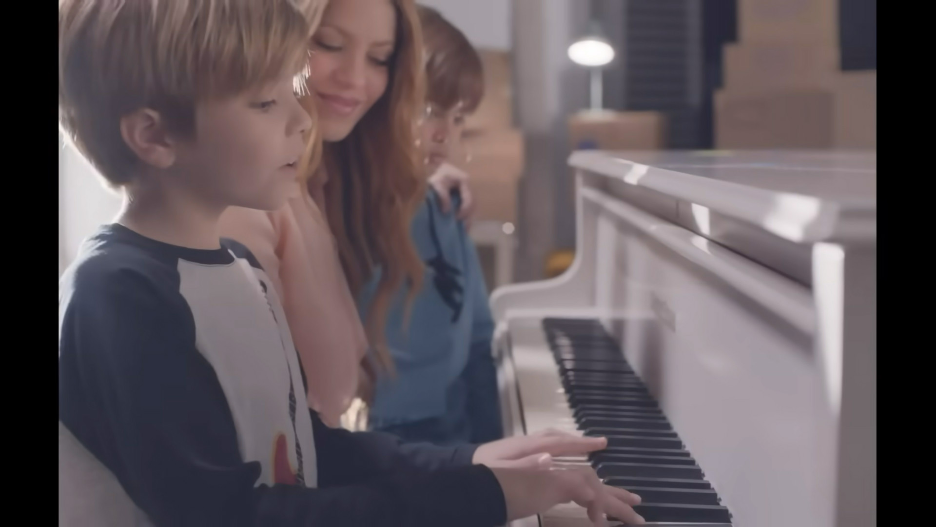 Shakira y sus hijos, Milan y Sasha, frente al piano en el video de "Acróstico". Captura video YouTube.