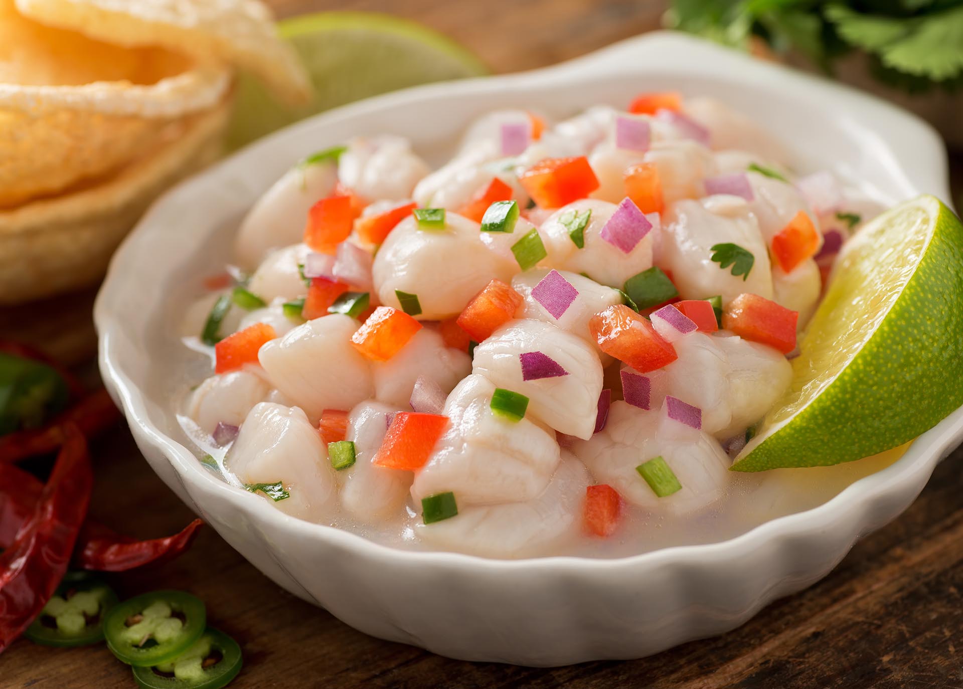 A freshly made scallop ceviche with red onion, cilantro, red pepper, lime, and serrano pepper.