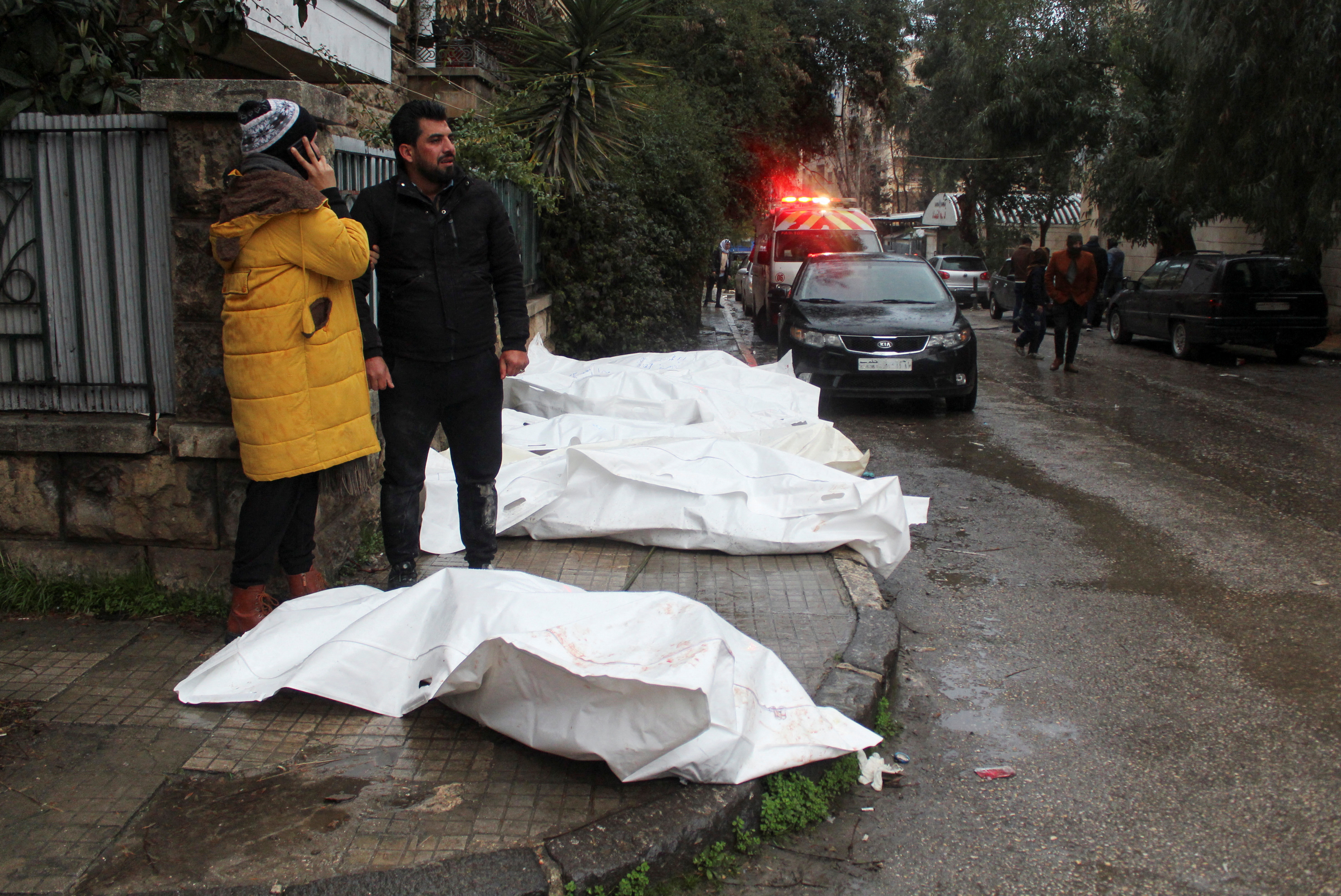Sobrevivientes junto a bolsas de cadáveres en Alepo (REUTERS/Firas Makdesi)