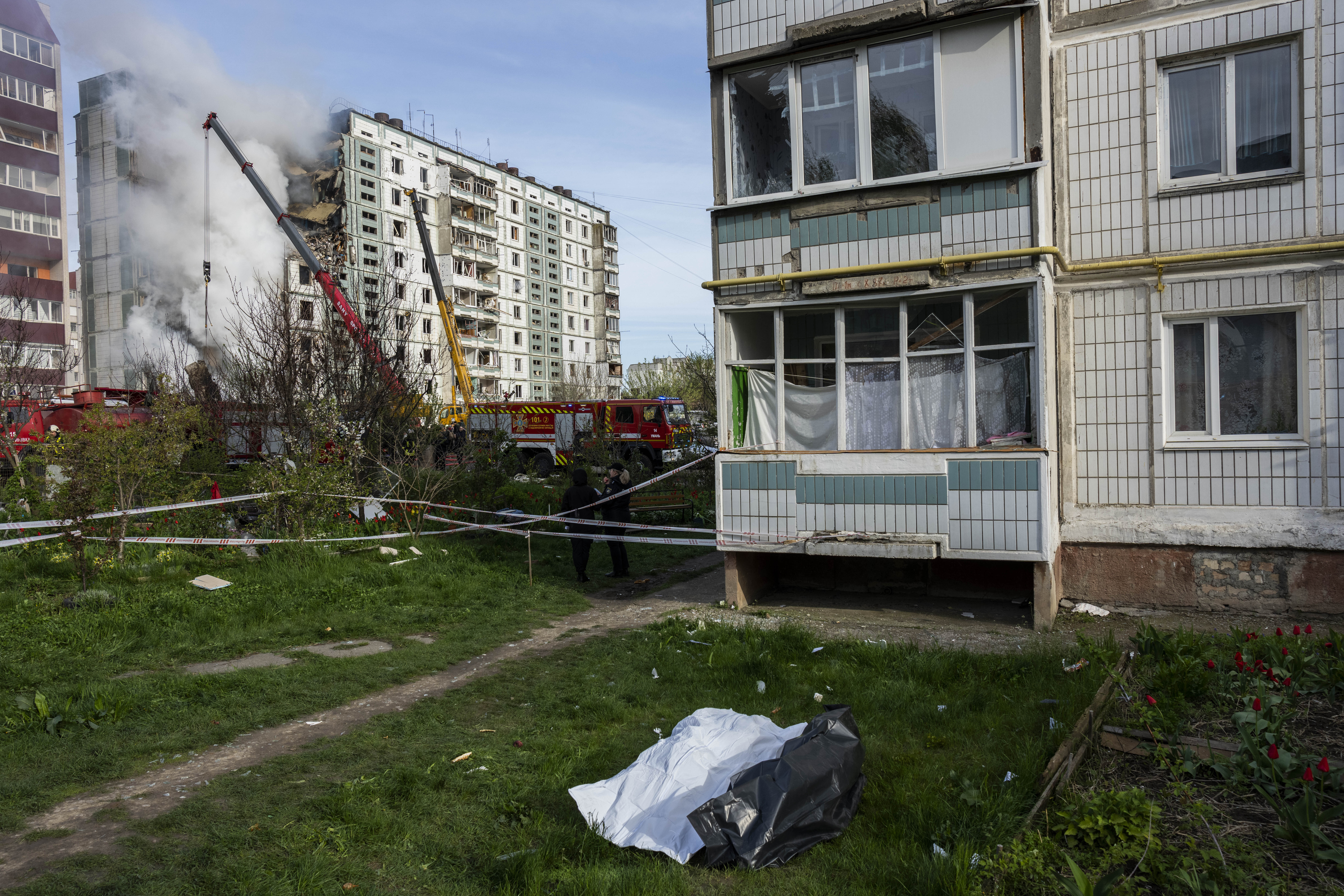 Cuerpos recuperados de una zona residencial que fue golpeada durante un ataque ruso yacen en el suelo en Uman, Ucrania central, el viernes 28 de abril de 2023. (AP/Bernat Armangue)