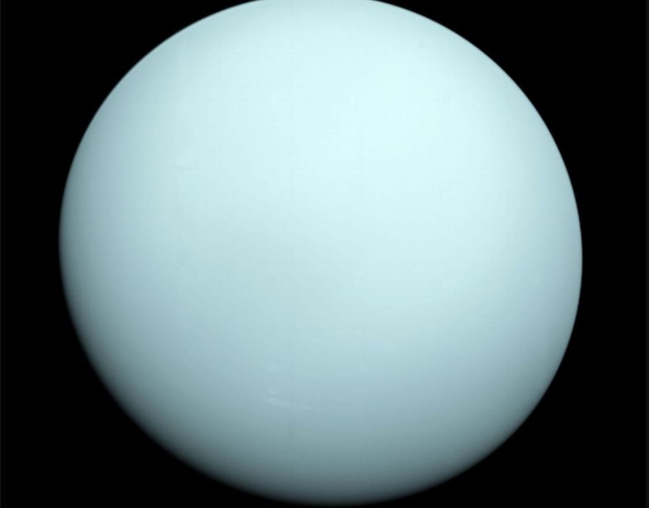 Al llegar a Urano en 1986, la Voyager 2 observó un orbe azulado con rasgos extremadamente sutiles. Una capa de neblina ocultaba a la vista la mayoría de las características de las nubes del planeta. (NASA/JPL-CALTECH)
