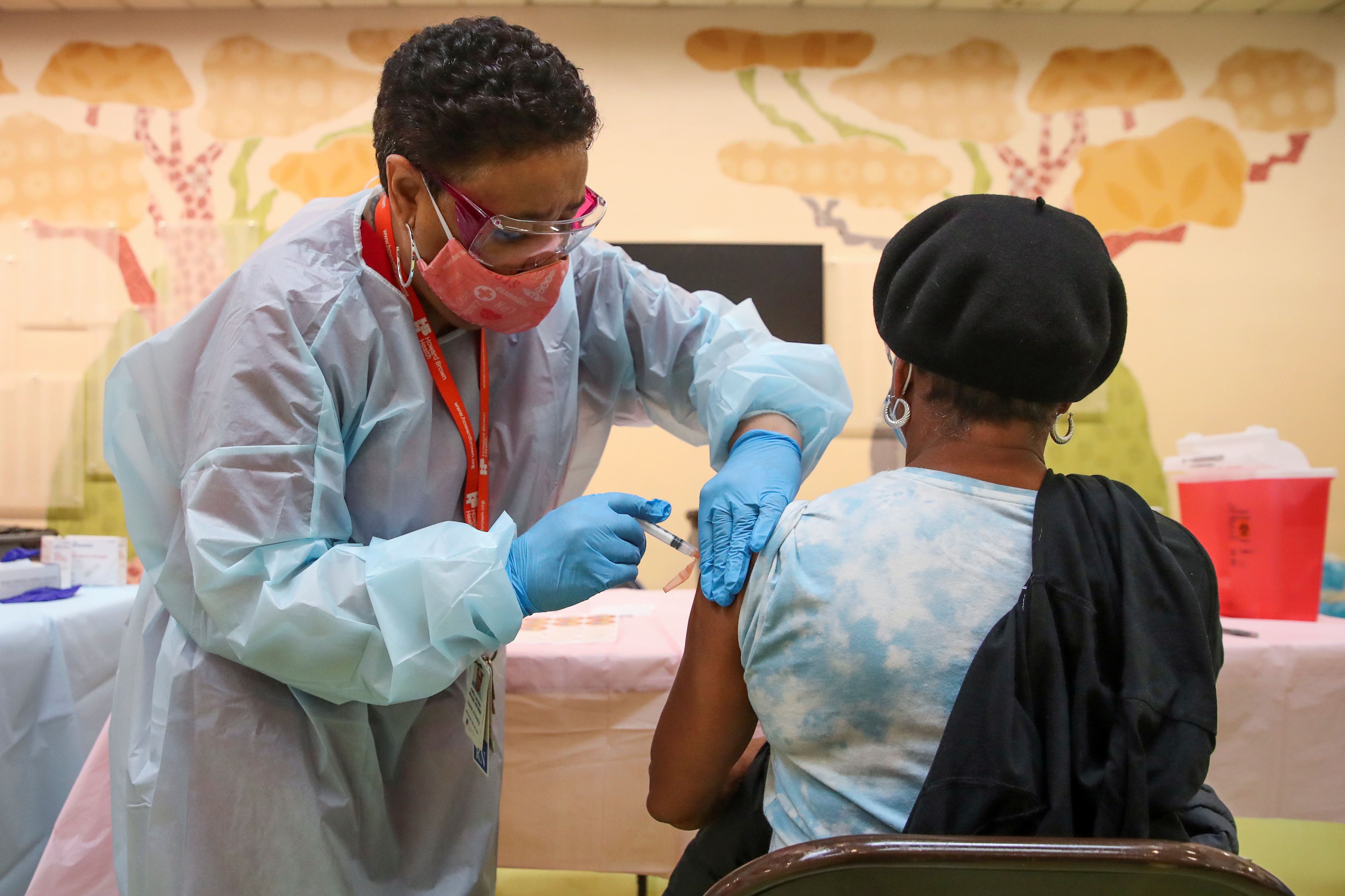 Una mujer recibe la vacuna contra la enfermedad del coronavirus Moderna (COVID-19) de manos de la enfermera Kathy McLoyd (L) en la Iglesia Unida de Cristo de la Trinidad en Chicago, Illinois, Estados Unidos, el 13 de febrero de 2021.  REUTERS/Kamil Krzaczynski