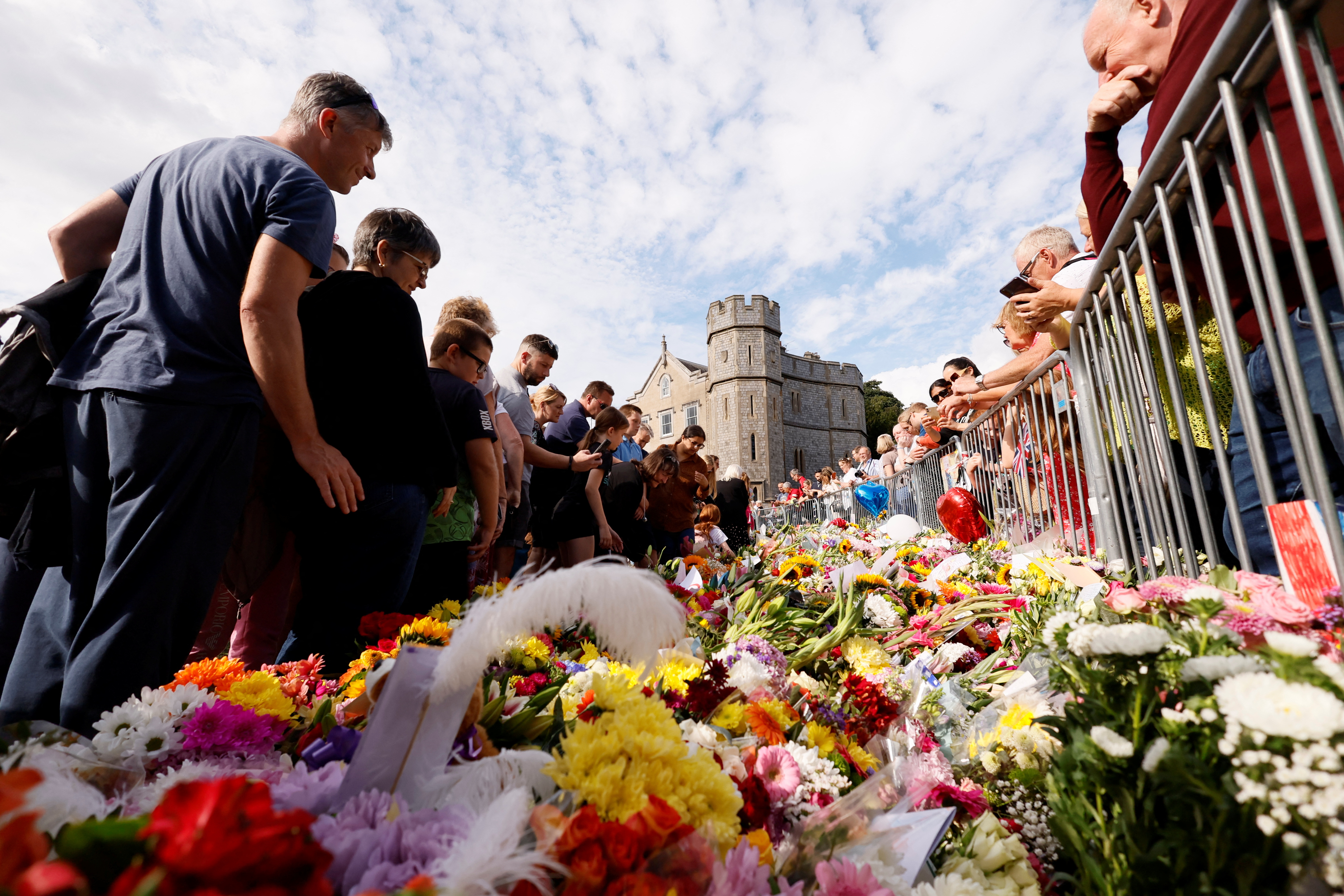 La gente se reúne para poner flores fuera del Castillo de Windsor, tras la muerte de la Reina Isabel. (REUTERS/Andrew Couldridge)