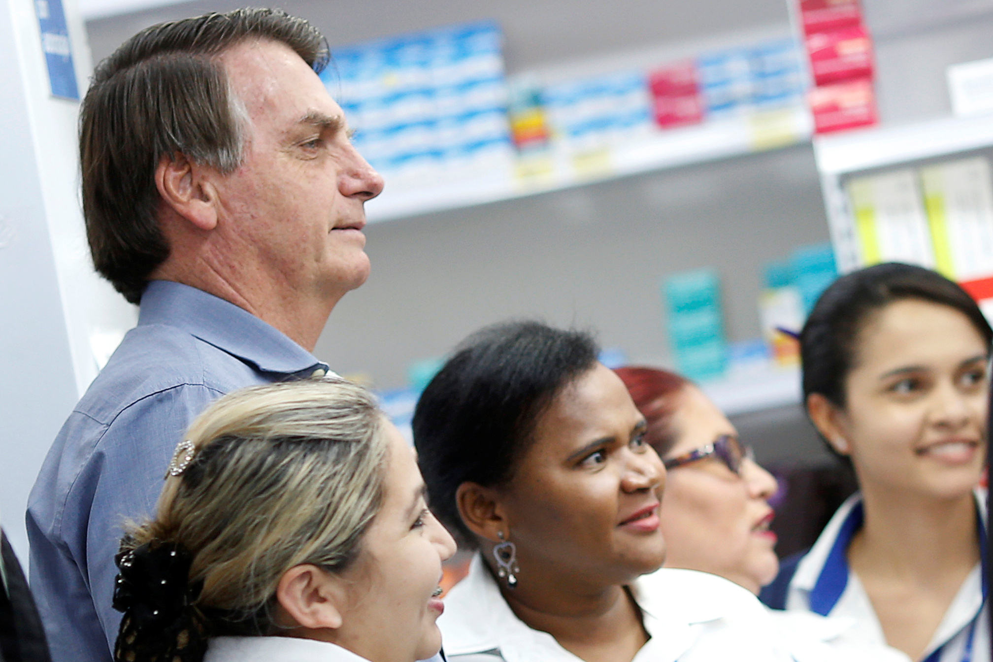 Jair Bolsonaro posa para las cámaras junto a empleadas de una farmacia en Brasilia, todos ellos sin protección, el pasado 10 de abril durante el brote de coronavirus REUTERS/Adriano Machado