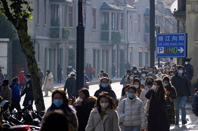 Personas con mascarillas caminan por una calle mientras continúan los brotes de la enfermedad por coronavirus (COVID-19) en Shanghái. (REUTERS/Aly Song)